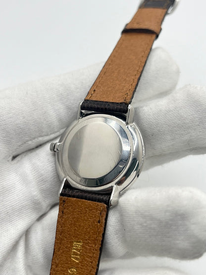 Montre Omega De Ville vintage référence 111.077 en acier, fabriquée en 1969. Ce modèle à remontage manuel est doté d'un cadran argent avec chiffres romains, d'un verre en plexiglas et d'un boîtier de 33 mm. Le bracelet en cuir noir avec boucle ardillon en acier complète son style classique et intemporel. Cette montre d'occasion révisée séduit les amateurs d'horlogerie vintage et de montres Omega de collection.

