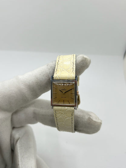 Montre Omega De Ville 511.087 vintage pour femme en acier, fabriquée en 1966. Cette montre élégante est dotée d'un cadran champagne avec index bâtons, d'un mouvement à remontage manuel calibre 620 et d'un verre en plexiglas. Elle est montée sur un bracelet en cuir beige avec boucle ardillon en acier. Son format de 19,5 mm lui confère une allure raffinée et intemporelle. Montre de collection en très bon état d'occasion, révisée et prête à être portée.