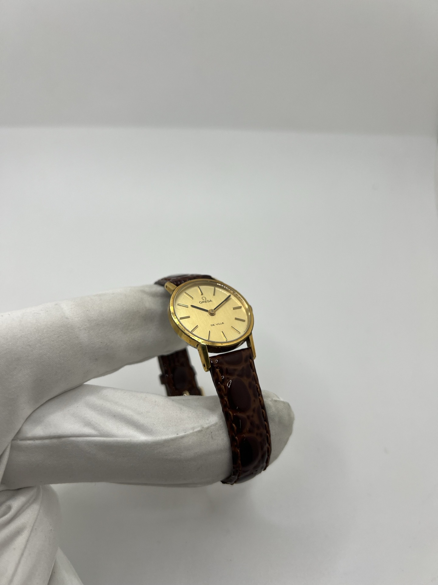 Montre Omega De Ville 511.0392 vintage de 1973 en acier plaqué or avec cadran doré et bracelet cuir brun. Cette Omega Seamaster De Ville mécanique de 24 mm est équipée du calibre Omega 625 à remontage manuel, apprécié pour son charme horloger authentique. Élégante et raffinée, cette Omega vintage femme séduit par son style intemporel inspiré des années 70. Montre révisée avec boucle Omega d’origine, boîte Omega et certificat d’authenticité.