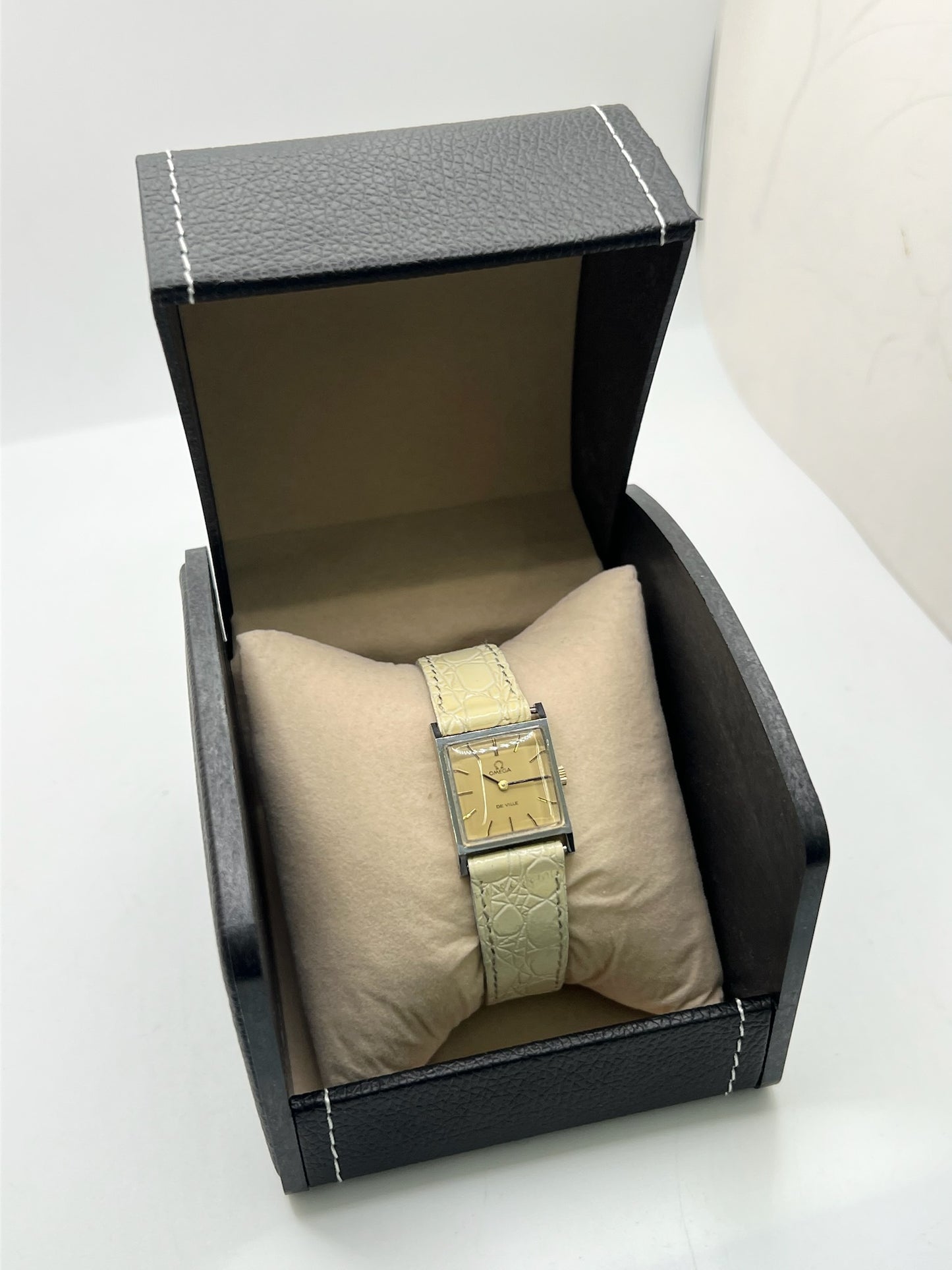 Montre Omega De Ville 511.087 vintage pour femme en acier, fabriquée en 1966. Cette montre élégante est dotée d'un cadran champagne avec index bâtons, d'un mouvement à remontage manuel calibre 620 et d'un verre en plexiglas. Elle est montée sur un bracelet en cuir beige avec boucle ardillon en acier. Son format de 19,5 mm lui confère une allure raffinée et intemporelle. Montre de collection en très bon état d'occasion, révisée et prête à être portée.