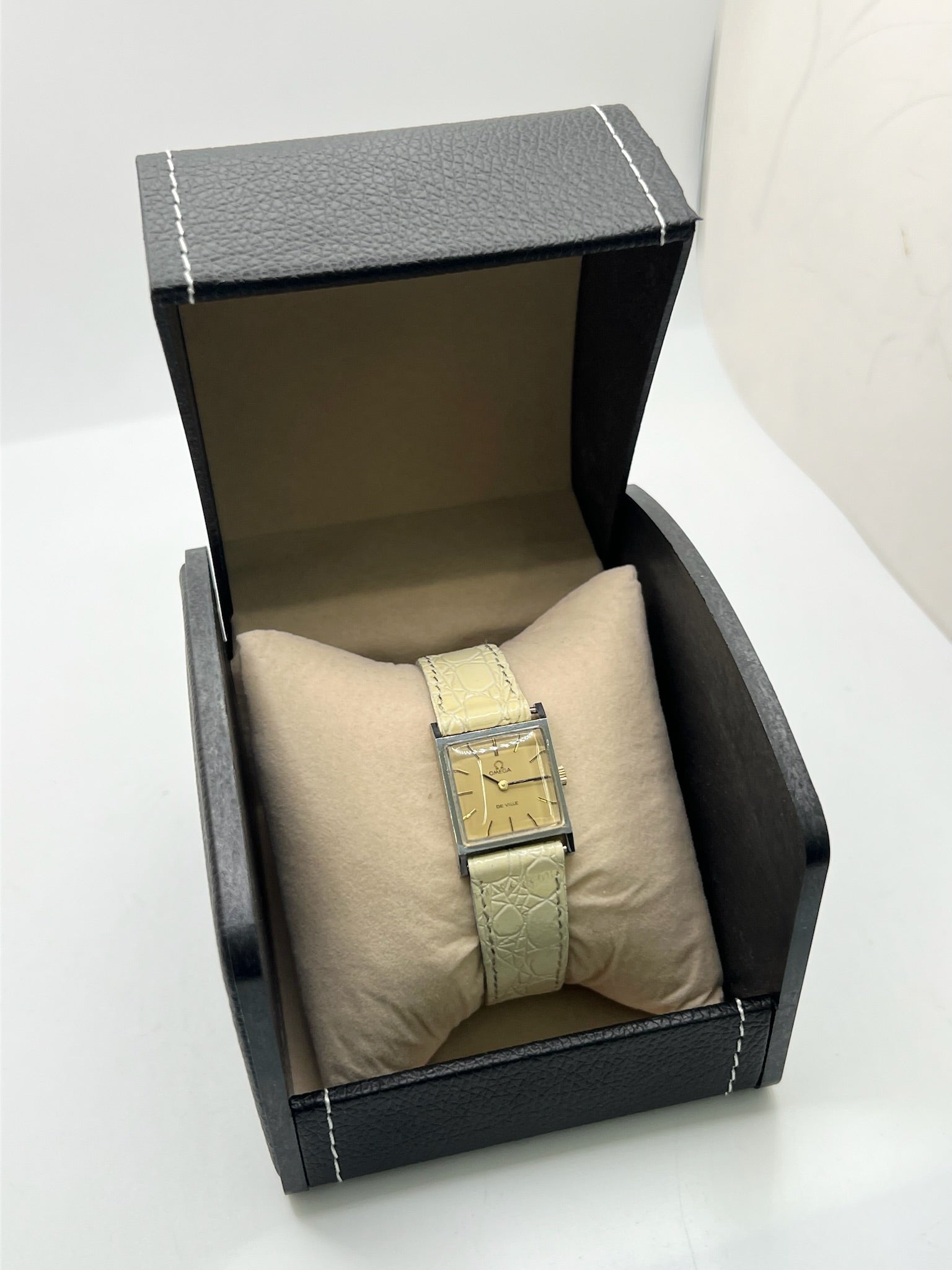 Montre Omega De Ville 511.087 vintage pour femme en acier, fabriquée en 1966. Cette montre élégante est dotée d'un cadran champagne avec index bâtons, d'un mouvement à remontage manuel calibre 620 et d'un verre en plexiglas. Elle est montée sur un bracelet en cuir beige avec boucle ardillon en acier. Son format de 19,5 mm lui confère une allure raffinée et intemporelle. Montre de collection en très bon état d'occasion, révisée et prête à être portée.