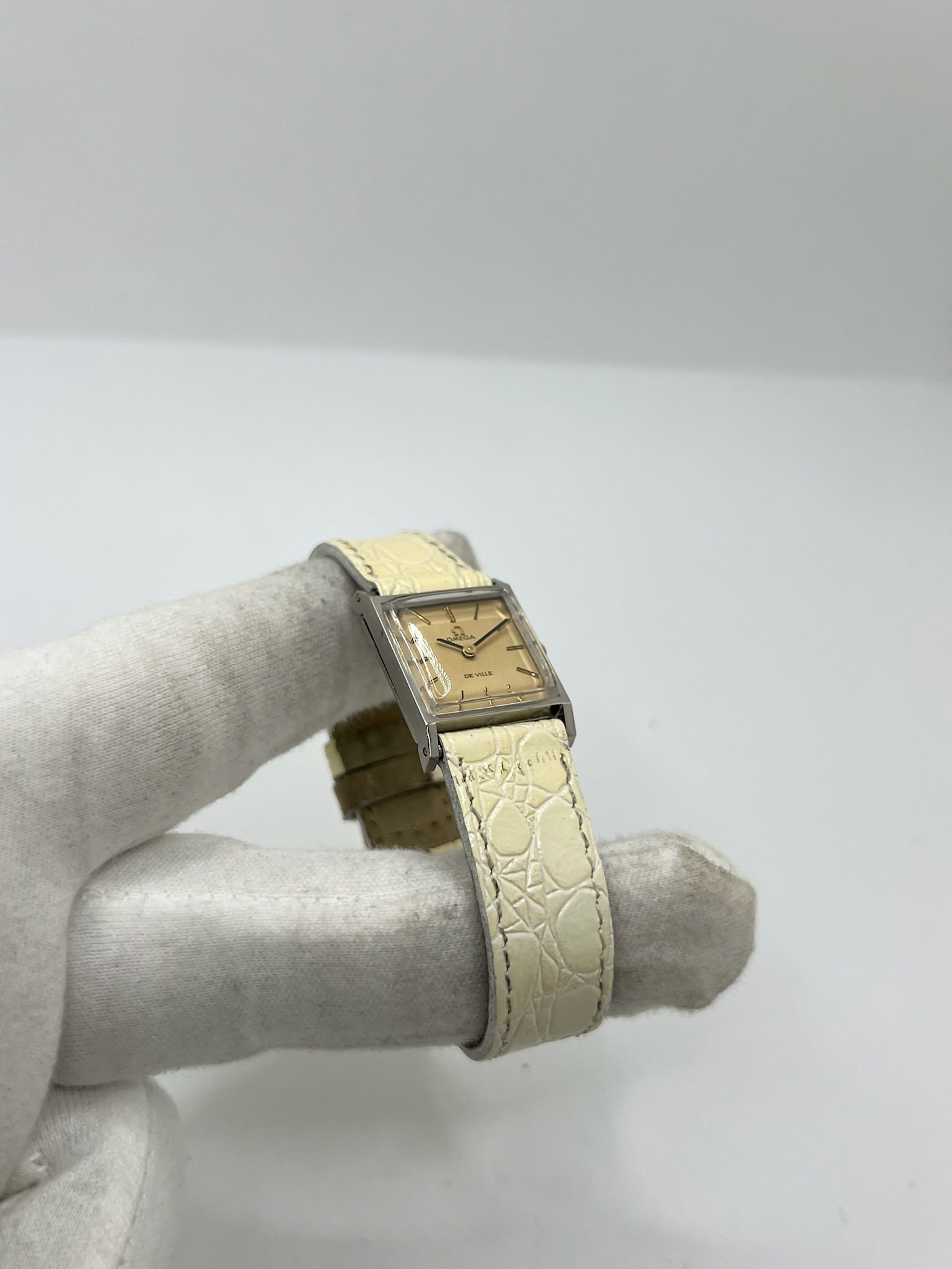 Montre Omega De Ville 511.087 vintage pour femme en acier, fabriquée en 1966. Cette montre élégante est dotée d'un cadran champagne avec index bâtons, d'un mouvement à remontage manuel calibre 620 et d'un verre en plexiglas. Elle est montée sur un bracelet en cuir beige avec boucle ardillon en acier. Son format de 19,5 mm lui confère une allure raffinée et intemporelle. Montre de collection en très bon état d'occasion, révisée et prête à être portée.