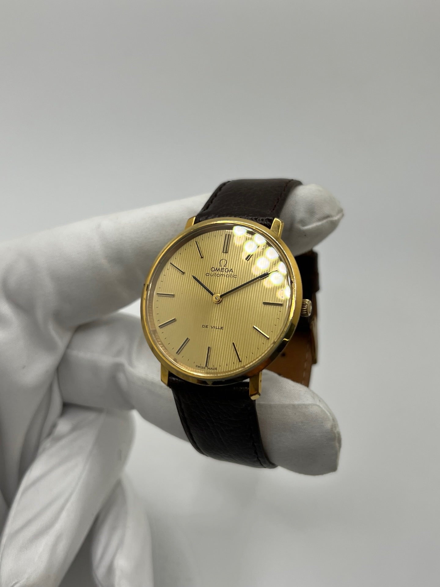 Montre Omega De Ville référence 151.0039 vintage de 1973 en acier avec mouvement automatique calibre 711, cadran doré et bracelet en cuir noir. Ce modèle homme ou unisexe de 35,5 mm présente un design élégant et intemporel. Montre d’occasion en très bon état, révisée en interne le 13 mars 2026, avec légères traces d’usure discrètes. Pièce classique de collection sans coffret ni papiers d’origine.