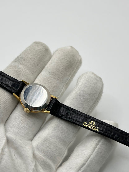 Montre Omega Genève référence 511.0451 pour femme, fabriquée en 1969, avec boîtier en acier de 17 mm et mouvement à remontage manuel. Son élégant cadran argent apporte une touche vintage intemporelle, protégé par un boîtier sobre et raffiné. Elle est montée sur un bracelet en cuir noir avec boucle ardillon en acier. Cette montre Omega d'occasion est en très bon état, révisée en interne et constitue une pièce de collection idéale pour les amateurs d'horlogerie vintage.