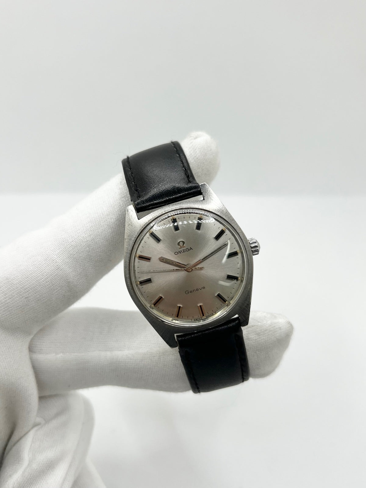 Montre Omega Genève 135.041 vintage de 1969, équipée d’un mouvement à remontage manuel avec calibre 601, offrant une réserve de marche de 48 heures. Son boîtier en acier de 34 mm est associé à un cadran argent à index bâtons, protégé par un verre Plexiglas. Cette Omega Genève est montée sur un bracelet noir en cuir de vache avec boucle ardillon en acier. En bon état, elle présente des traces d’usure visibles.