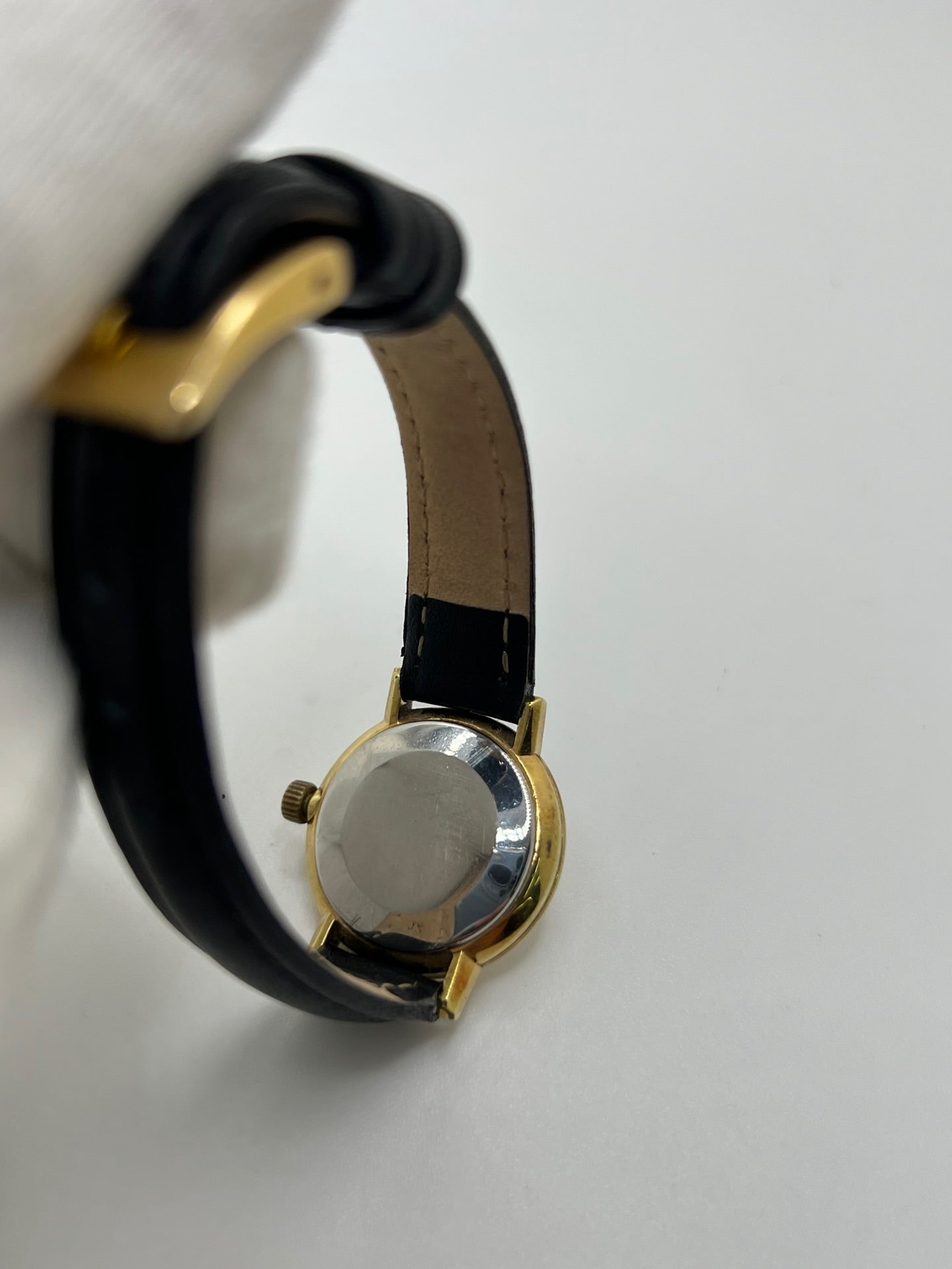 Montre Omega Genève femme vintage de 1972 en plaqué or, avec mouvement à remontage manuel. Boîtier de 23 mm au cadran doré orné de pierres précieuses et verre en plastique. Bracelet en cuir noir avec boucle en acier. Modèle élégant et intemporel, en bon état avec traces d’usure visibles. Révisée en avril 2026, vendue sans coffret ni papiers, disponible en stock en France.