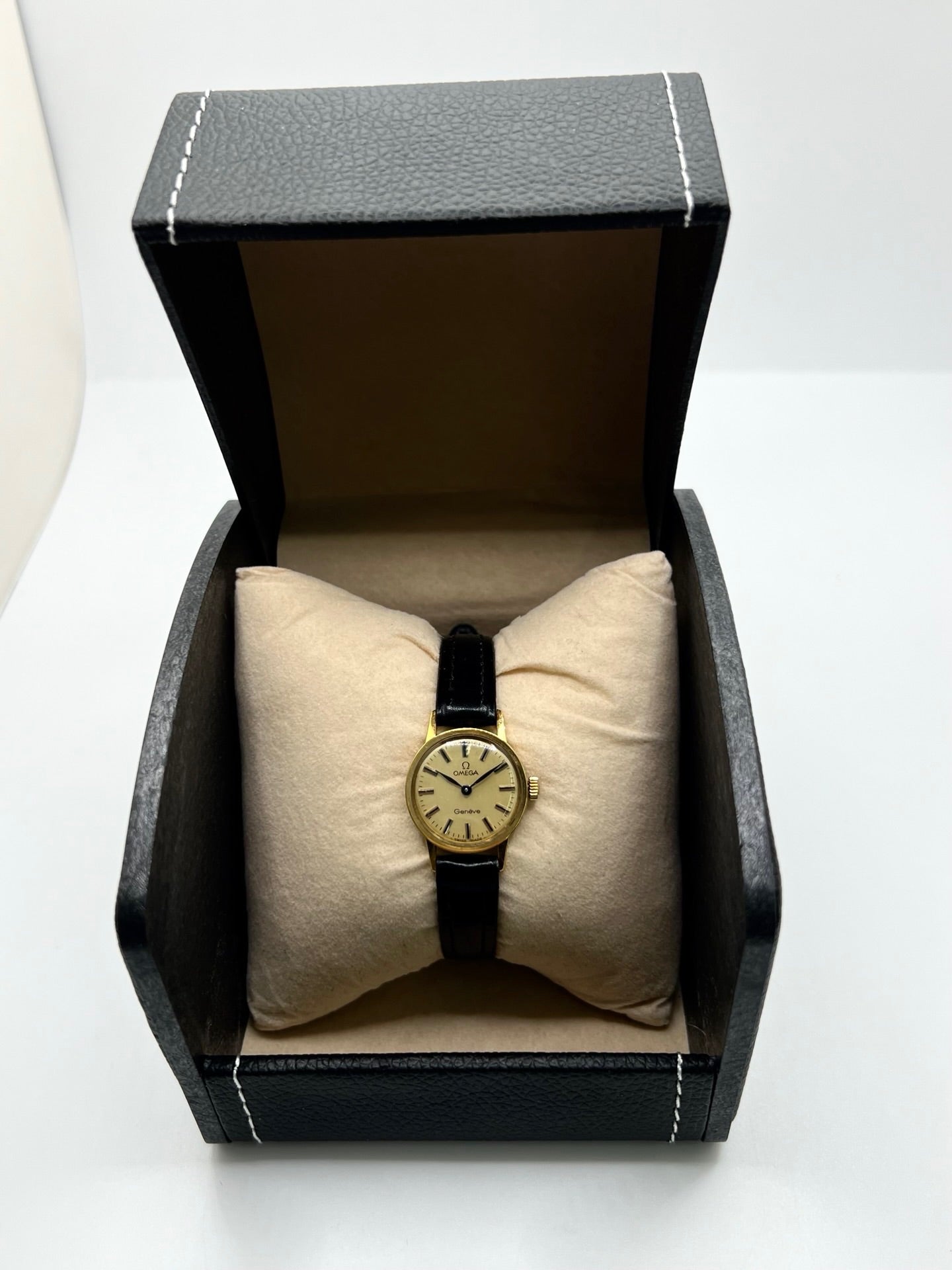 Montre Omega Genève référence 511.0451 pour femme, fabriquée en 1969, avec boîtier en acier de 17 mm et mouvement à remontage manuel. Son élégant cadran argent apporte une touche vintage intemporelle, protégé par un boîtier sobre et raffiné. Elle est montée sur un bracelet en cuir noir avec boucle ardillon en acier. Cette montre Omega d'occasion est en très bon état, révisée en interne et constitue une pièce de collection idéale pour les amateurs d'horlogerie vintage.