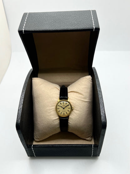 Montre Omega Genève référence 511.0451 pour femme, fabriquée en 1969, avec boîtier en acier de 17 mm et mouvement à remontage manuel. Son élégant cadran argent apporte une touche vintage intemporelle, protégé par un boîtier sobre et raffiné. Elle est montée sur un bracelet en cuir noir avec boucle ardillon en acier. Cette montre Omega d'occasion est en très bon état, révisée en interne et constitue une pièce de collection idéale pour les amateurs d'horlogerie vintage.