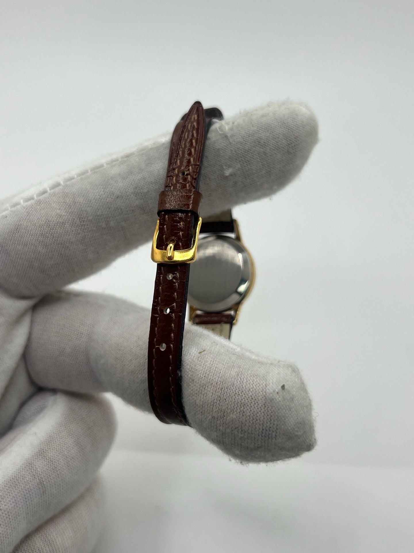 Montre Omega Genève Lady en acier avec boîtier plaqué or de 20 mm, cadran or à index bâtons, mouvement calibre 560, bracelet en cuir brun avec boucle acier. Vintage de 1978, d'occasion en bon état avec traces d'usure visibles. Verre plexiglas, modèle élégant pour femme, idéal pour collection ou usage quotidien. Livrée sans coffret ni papiers d'origine, disponible en stock à Paris.