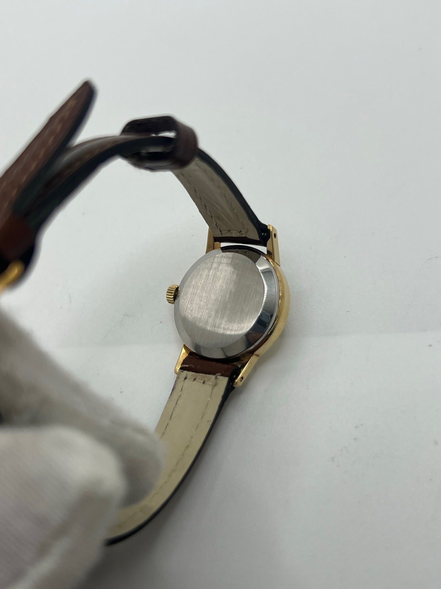 Montre Omega Genève Lady en acier avec boîtier plaqué or de 20 mm, cadran or à index bâtons, mouvement calibre 560, bracelet en cuir brun avec boucle acier. Vintage de 1978, d'occasion en bon état avec traces d'usure visibles. Verre plexiglas, modèle élégant pour femme, idéal pour collection ou usage quotidien. Livrée sans coffret ni papiers d'origine, disponible en stock à Paris.