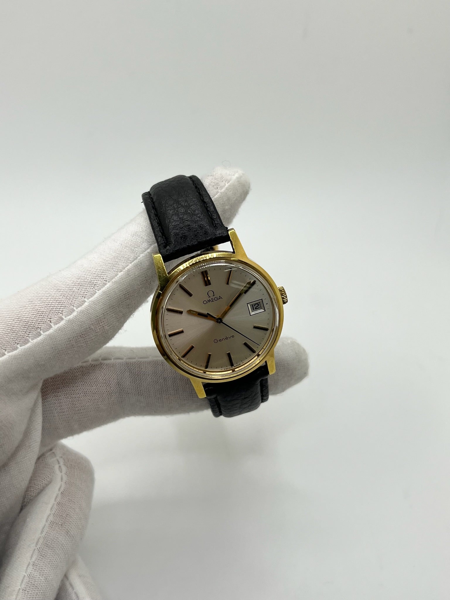 Montre Omega Genève vintage de 35 mm associant or et acier, au design classique et élégant. Cadran doré sobre offrant une lecture claire, complété par un affichage de la date. Boîtier équilibré et proportions harmonieuses, animé par un mouvement mécanique à remontage manuel révisé en interne. Bracelet en cuir noir apportant contraste et confort au poignet. Modèle en bon état d’usage, présentant des traces d’usure visibles telles que rayures, éraflures et petites marques liées à son âge et à son histoire.
