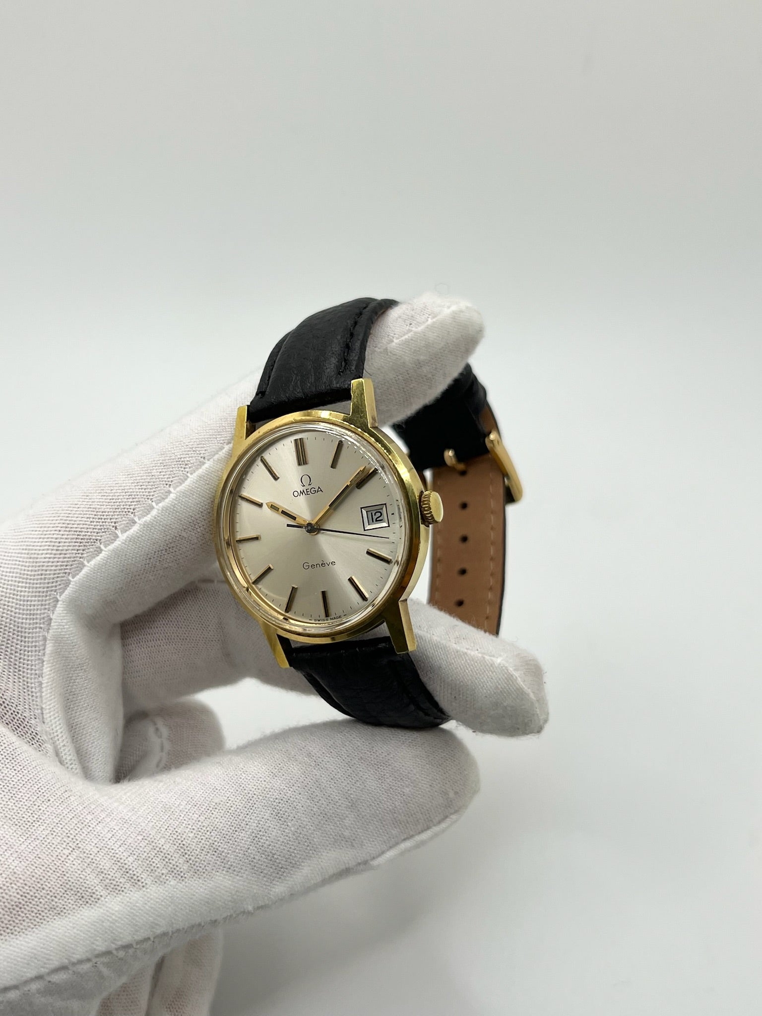 Montre Omega Genève vintage de 35 mm associant or et acier, au design classique et élégant. Cadran doré sobre offrant une lecture claire, complété par un affichage de la date. Boîtier équilibré et proportions harmonieuses, animé par un mouvement mécanique à remontage manuel révisé en interne. Bracelet en cuir noir apportant contraste et confort au poignet. Modèle en bon état d’usage, présentant des traces d’usure visibles telles que rayures, éraflures et petites marques liées à son âge et à son histoire.