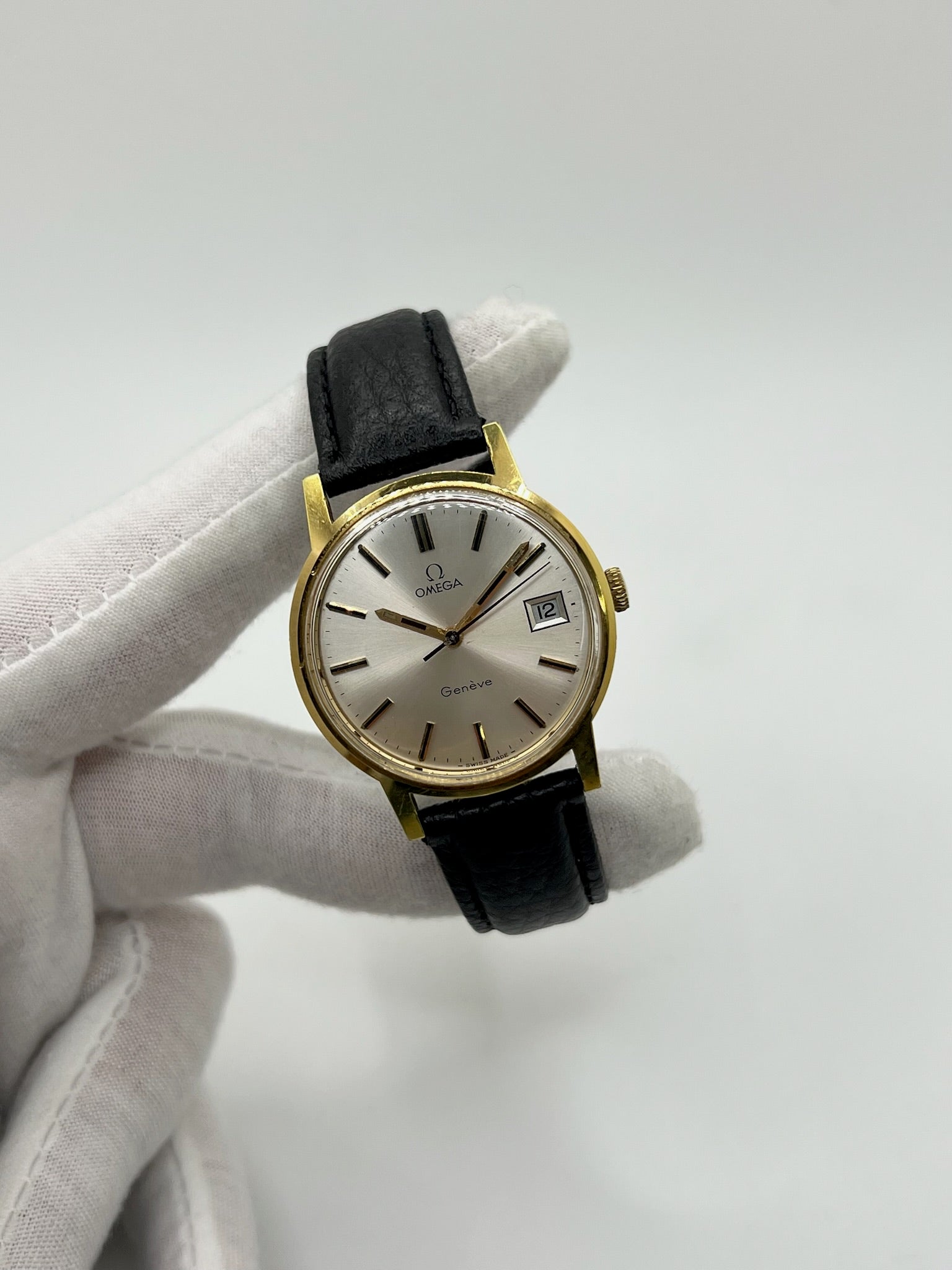 Montre Omega Genève vintage de 35 mm associant or et acier, au design classique et élégant. Cadran doré sobre offrant une lecture claire, complété par un affichage de la date. Boîtier équilibré et proportions harmonieuses, animé par un mouvement mécanique à remontage manuel révisé en interne. Bracelet en cuir noir apportant contraste et confort au poignet. Modèle en bon état d’usage, présentant des traces d’usure visibles telles que rayures, éraflures et petites marques liées à son âge et à son histoire.