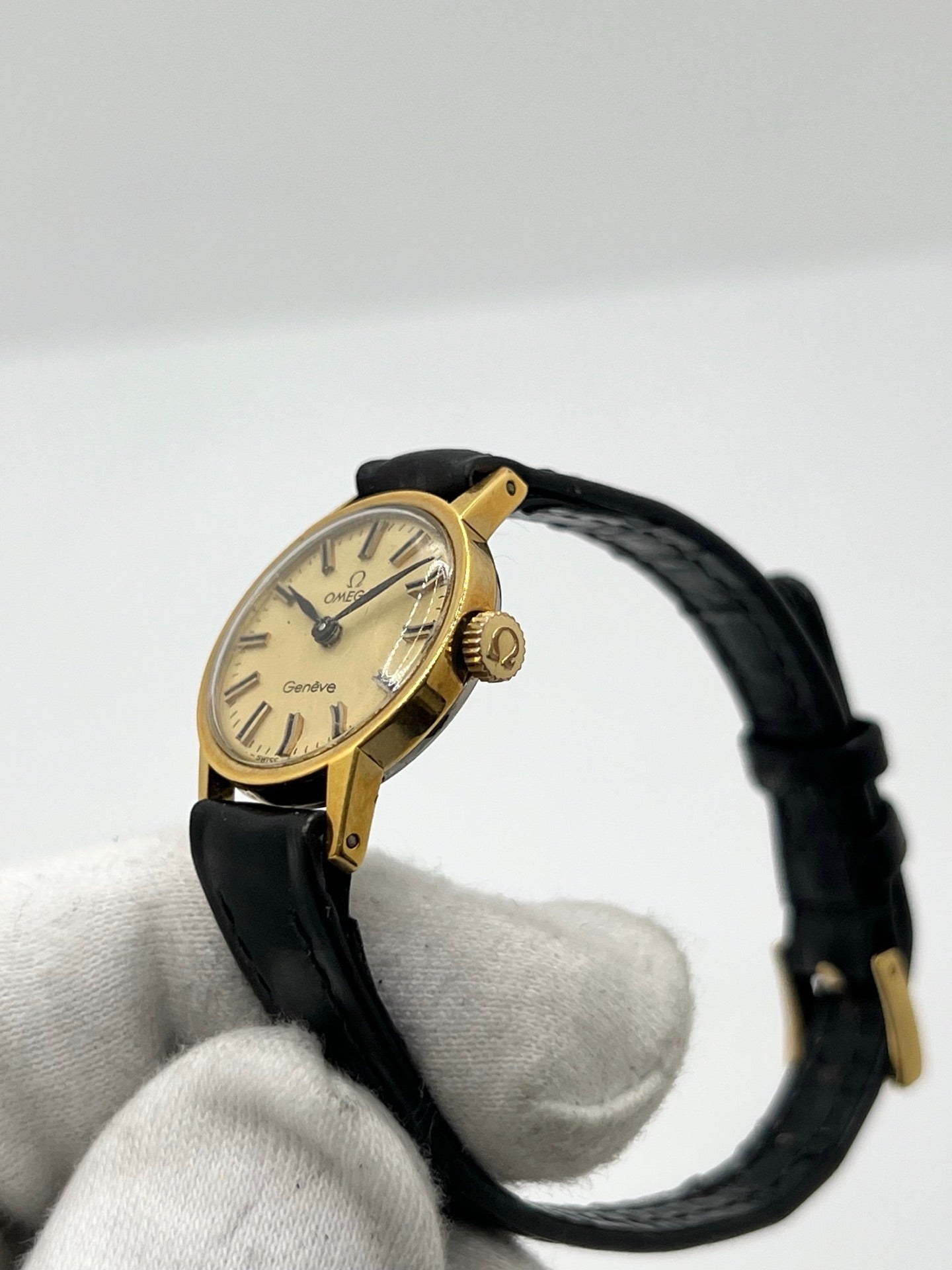 Montre Omega Genève référence 511.0451 pour femme, fabriquée en 1969, avec boîtier en acier de 17 mm et mouvement à remontage manuel. Son élégant cadran argent apporte une touche vintage intemporelle, protégé par un boîtier sobre et raffiné. Elle est montée sur un bracelet en cuir noir avec boucle ardillon en acier. Cette montre Omega d'occasion est en très bon état, révisée en interne et constitue une pièce de collection idéale pour les amateurs d'horlogerie vintage.