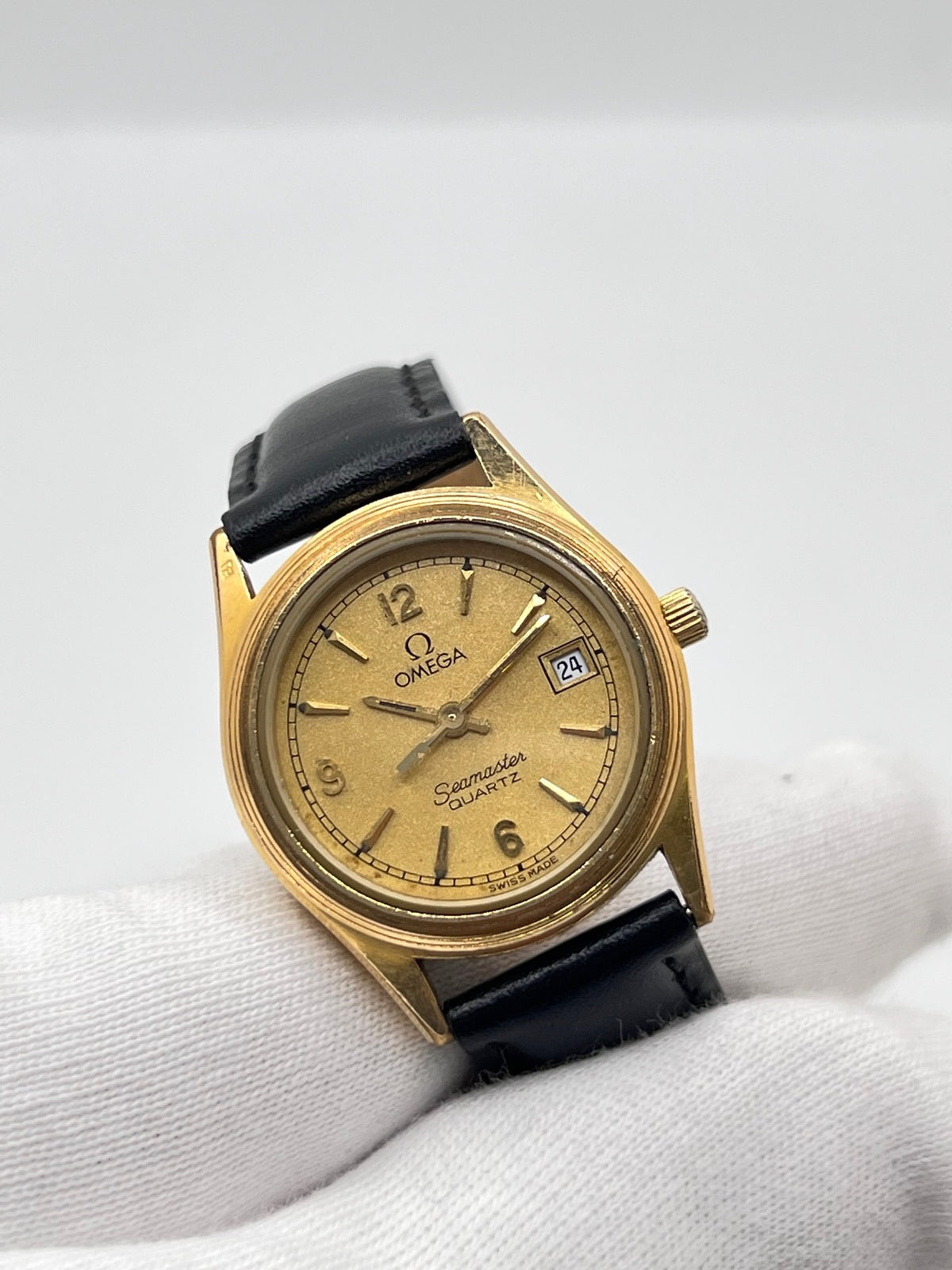 Montre Omega Seamaster 5960035 en très bon état, équipée d’un mouvement quartz et d’un boîtier plaqué or de 25 mm. Son cadran or à chiffres arabes est protégé par un verre saphir. Cette Omega Seamaster possède un bracelet en cuir noir avec boucle ardillon en acier. Destinée aux femmes, cette montre élégante dispose également d’une fonction date et est livrée avec son coffret d’origine. Un modèle intemporel alliant élégance et raffinement.