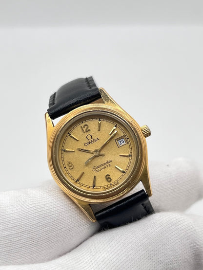 Montre Omega Seamaster 5960035 en très bon état, équipée d’un mouvement quartz et d’un boîtier plaqué or de 25 mm. Son cadran or à chiffres arabes est protégé par un verre saphir. Cette Omega Seamaster possède un bracelet en cuir noir avec boucle ardillon en acier. Destinée aux femmes, cette montre élégante dispose également d’une fonction date et est livrée avec son coffret d’origine. Un modèle intemporel alliant élégance et raffinement.