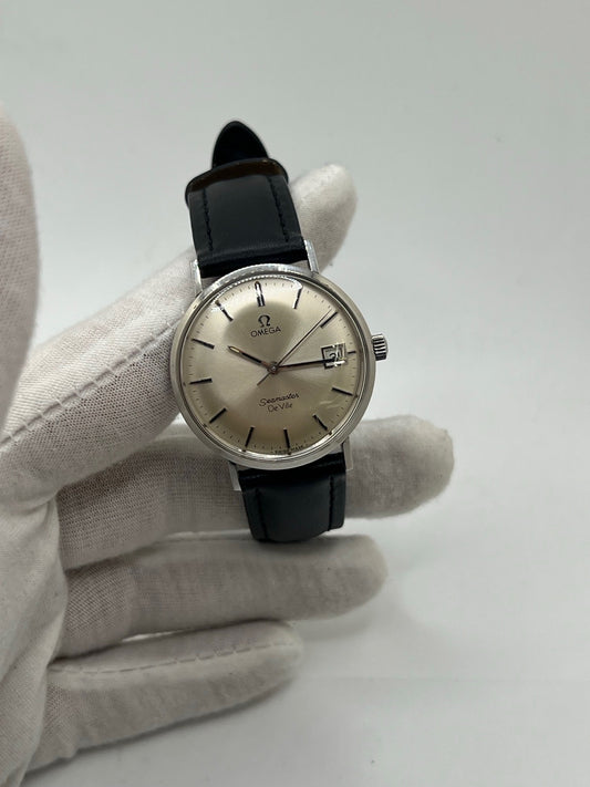 Montre Omega Seamaster DeVille vintage des années 60, à remontage manuel avec calibre 611. Boîtier en acier de 34 mm, cadran argent et bracelet en cuir. Ce modèle emblématique allie élégance et précision horlogère. Parfaite pour les amateurs de montres anciennes, cette Seamaster DeVille incarne le savoir-faire intemporel d’Omega.