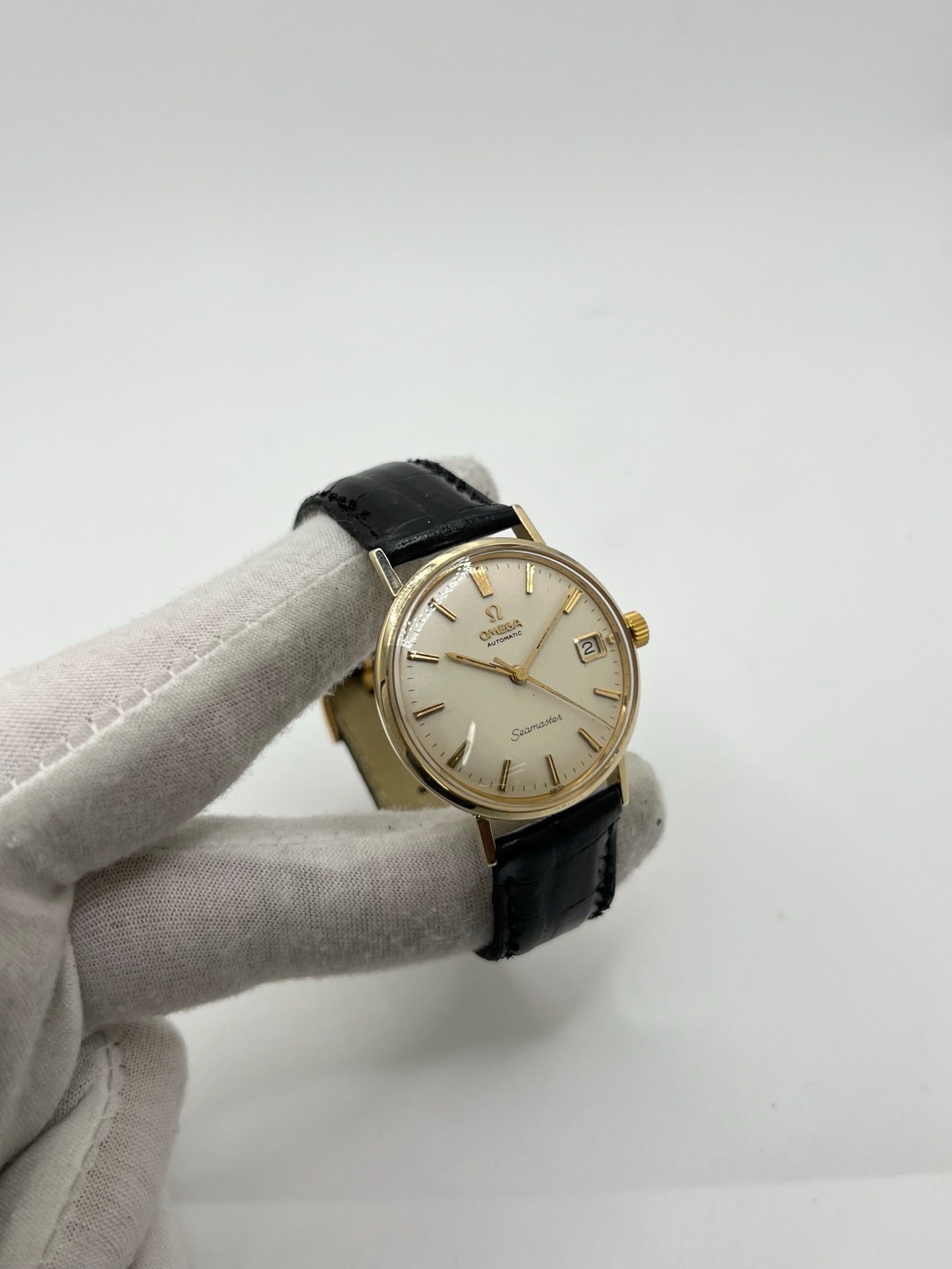 Montre Omega Seamaster DeVille vintage de 1961 en or jaune 14 carats, équipée d’un mouvement automatique calibre 560. Boîtier rond de 34 mm avec verre plexiglas, cadran champagne à index bâtons et date. Bracelet en cuir de crocodile noir avec boucle en or. Montre homme élégante et intemporelle, en bon état avec traces d’usure, récemment révisée, idéale pour collection ou usage quotidien.