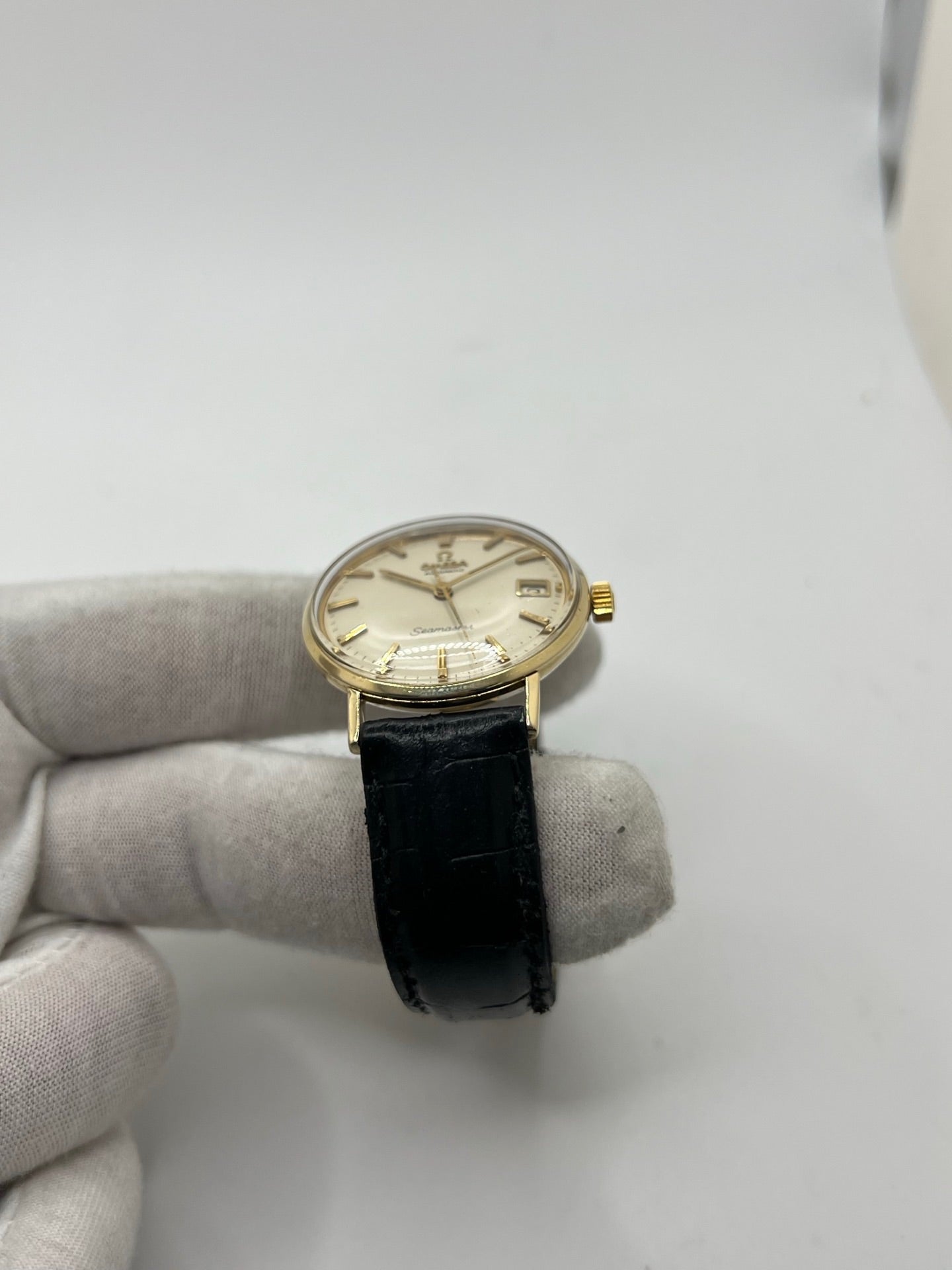 Montre Omega Seamaster DeVille vintage de 1961 en or jaune 14 carats, équipée d’un mouvement automatique calibre 560. Boîtier rond de 34 mm avec verre plexiglas, cadran champagne à index bâtons et date. Bracelet en cuir de crocodile noir avec boucle en or. Montre homme élégante et intemporelle, en bon état avec traces d’usure, récemment révisée, idéale pour collection ou usage quotidien.