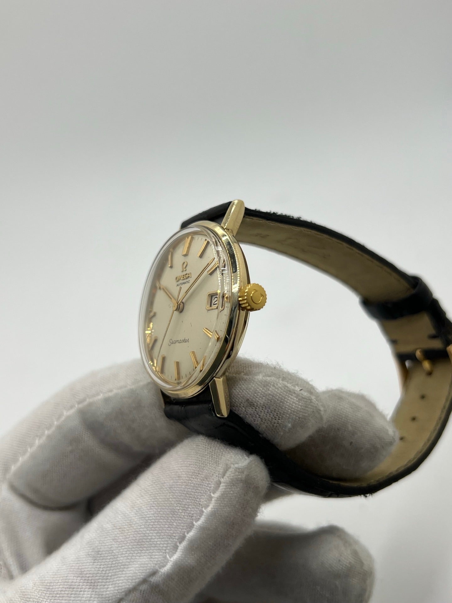 Montre Omega Seamaster DeVille vintage de 1961 en or jaune 14 carats, équipée d’un mouvement automatique calibre 560. Boîtier rond de 34 mm avec verre plexiglas, cadran champagne à index bâtons et date. Bracelet en cuir de crocodile noir avec boucle en or. Montre homme élégante et intemporelle, en bon état avec traces d’usure, récemment révisée, idéale pour collection ou usage quotidien.