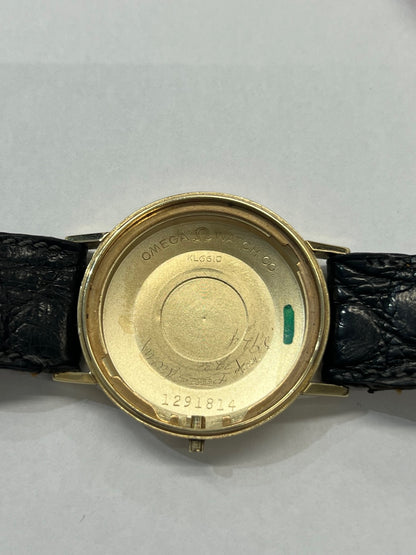 Montre Omega Seamaster DeVille vintage de 1961 en or jaune 14 carats, équipée d’un mouvement automatique calibre 560. Boîtier rond de 34 mm avec verre plexiglas, cadran champagne à index bâtons et date. Bracelet en cuir de crocodile noir avec boucle en or. Montre homme élégante et intemporelle, en bon état avec traces d’usure, récemment révisée, idéale pour collection ou usage quotidien.