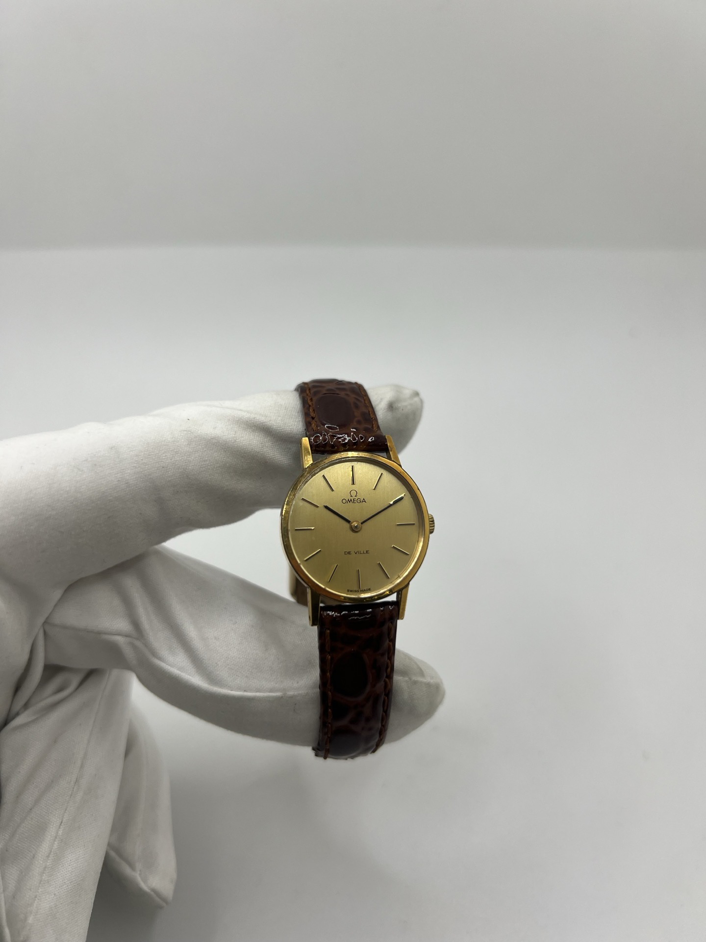 Montre Omega De Ville 511.0392 vintage de 1973 en acier plaqué or avec cadran doré et bracelet cuir brun. Cette Omega Seamaster De Ville mécanique de 24 mm est équipée du calibre Omega 625 à remontage manuel, apprécié pour son charme horloger authentique. Élégante et raffinée, cette Omega vintage femme séduit par son style intemporel inspiré des années 70. Montre révisée avec boucle Omega d’origine, boîte Omega et certificat d’authenticité.