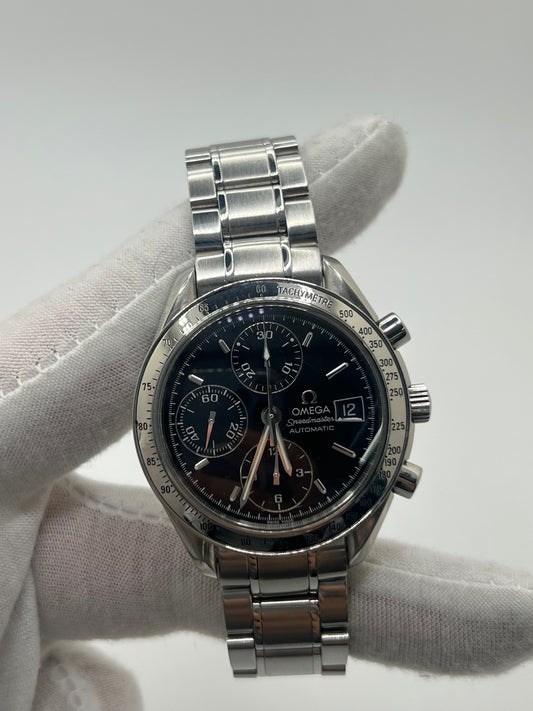 Montre Omega Speedmaster Date référence 3513.50 en acier, chronographe automatique avec boîtier de 39 mm et bracelet en acier assorti. Cadran noir sobre sans chiffres, protégé par un verre saphir, avec affichage de la date et fonctions chronographe. Modèle étanche 5 ATM, animé par le calibre automatique 1152 offrant 44 heures de réserve de marche. Montre homme élégante et sportive, emblématique de la collection Speedmaster.