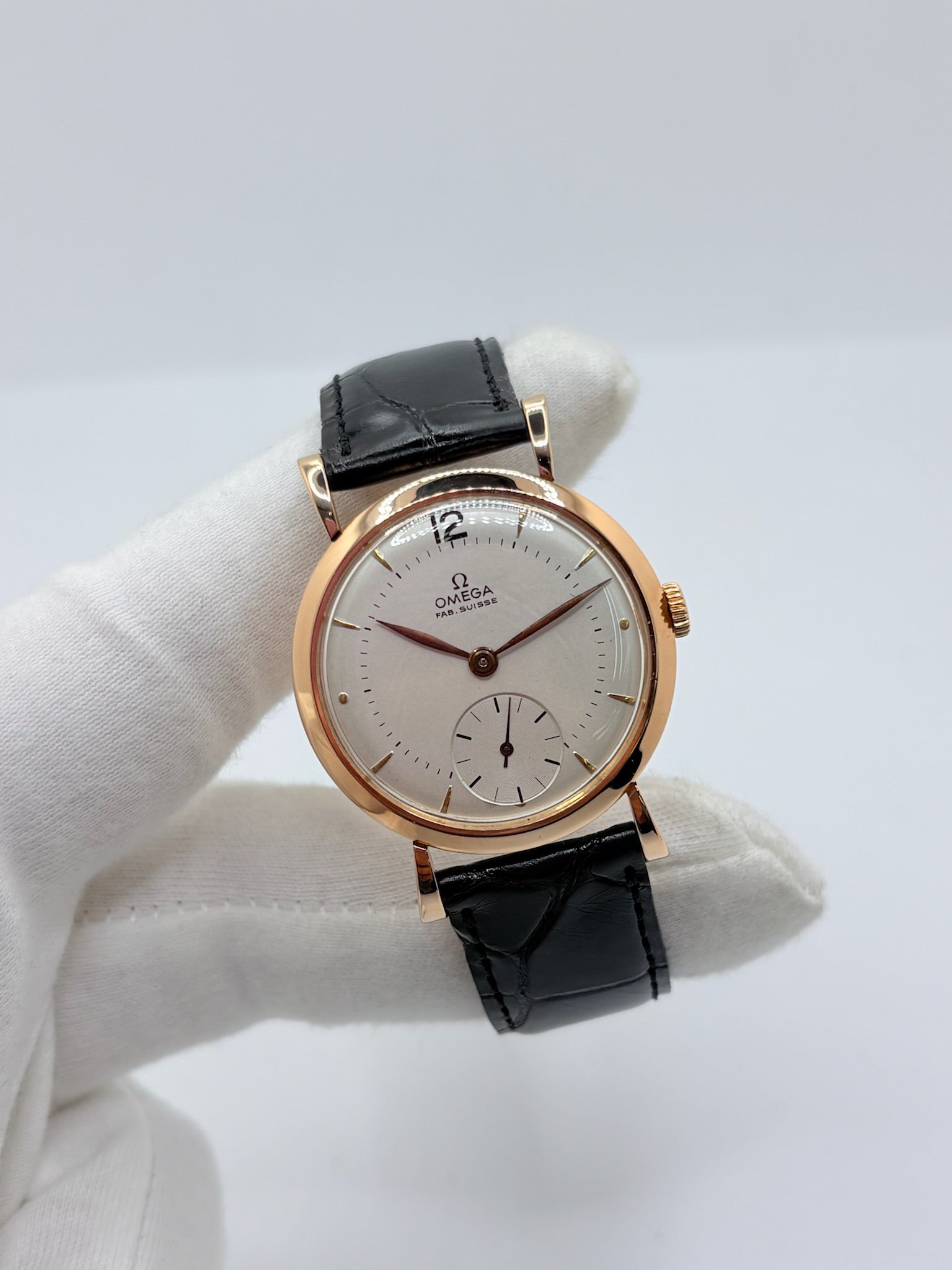 Montre Omega Vintage équipée du célèbre calibre mécanique 30T2 à remontage manuel. Cette montre ancienne, datant approximativement de 1948, présente un boîtier en or rose de 33 mm et un élégant cadran blanc à index bâtons. Son bracelet en cuir de crocodile noir complète son esthétique classique et intemporelle. Cette Omega Vintage calibre 30T2 incarne le charme d’une montre de collection, alliant savoir-faire horloger, élégance et authenticité.