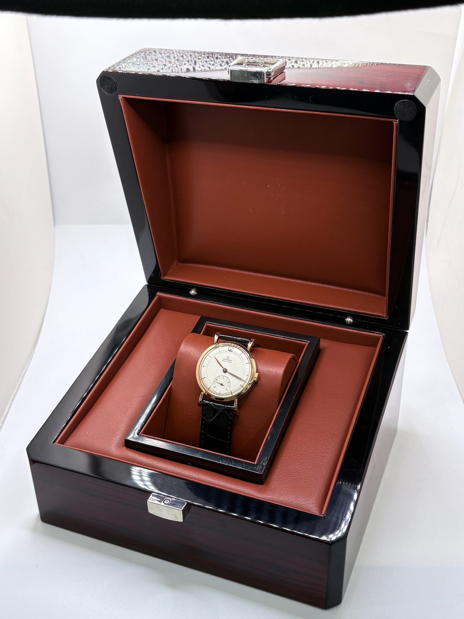 Montre Omega Vintage équipée du célèbre calibre mécanique 30T2 à remontage manuel. Cette montre ancienne, datant approximativement de 1948, présente un boîtier en or rose de 33 mm et un élégant cadran blanc à index bâtons. Son bracelet en cuir de crocodile noir complète son esthétique classique et intemporelle. Cette Omega Vintage calibre 30T2 incarne le charme d’une montre de collection, alliant savoir-faire horloger, élégance et authenticité.