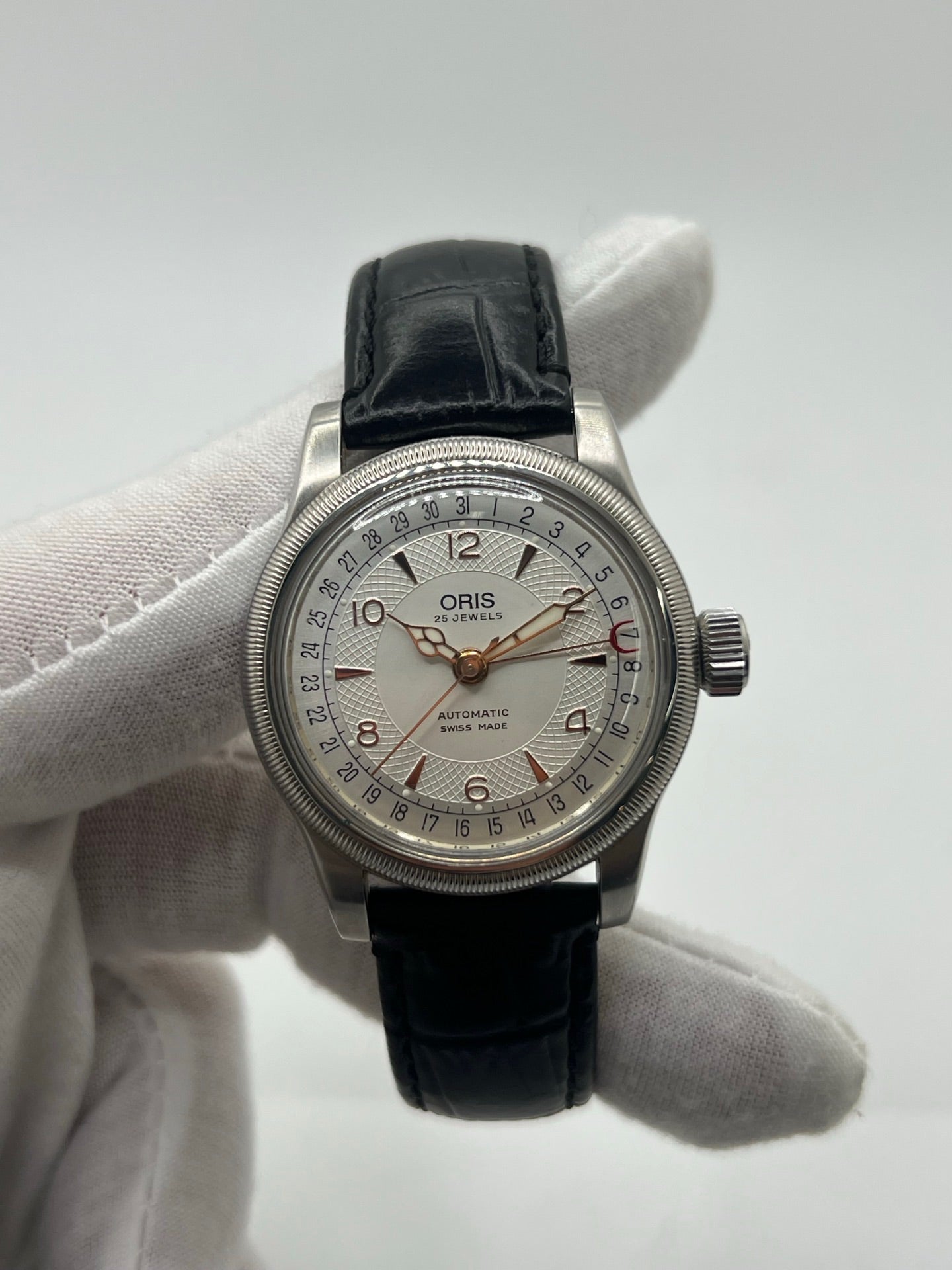 Montre mécanique automatique pour homme au style vintage, dotée d’un boîtier en acier de 36 mm et d’un cadran argent à chiffres arabes lisibles. Modèle équipé d’une fonction date par aiguille centrale, verre en matière plastique et lunette en acier. Bracelet noir avec boucle ardillon en acier. Montre d’occasion en très bon état, présentant de légères traces d’usure superficielles, récemment révisée, idéale pour les amateurs d’horlogerie classique.