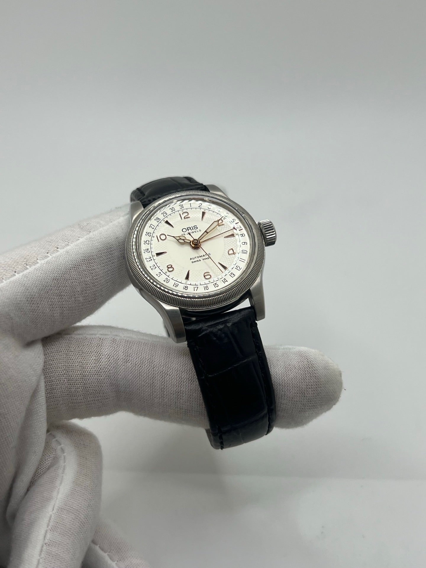Montre mécanique automatique pour homme au style vintage, dotée d’un boîtier en acier de 36 mm et d’un cadran argent à chiffres arabes lisibles. Modèle équipé d’une fonction date par aiguille centrale, verre en matière plastique et lunette en acier. Bracelet noir avec boucle ardillon en acier. Montre d’occasion en très bon état, présentant de légères traces d’usure superficielles, récemment révisée, idéale pour les amateurs d’horlogerie classique.