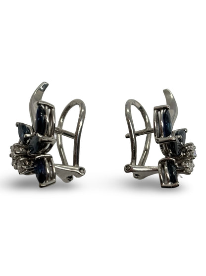 Boucles d’oreilles en or blanc 18K ornées de saphirs totalisant 0,60 ct et de diamants de 0,20 ct. Élégantes et raffinées, elles associent l’intensité bleue des saphirs à l’éclat subtil des diamants. Cette paire intemporelle sublime toutes les tenues et constitue un bijou précieux, idéal pour offrir ou compléter une collection de joaillerie fine.