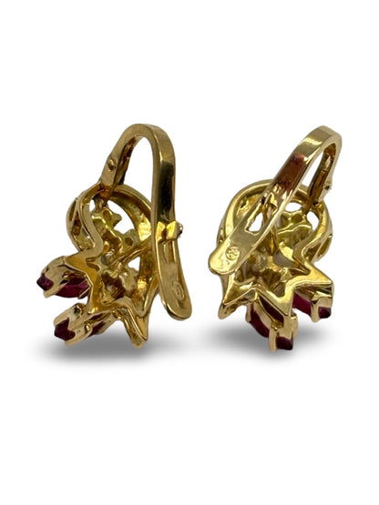 Boucles d’oreilles en or jaune 18K ornées de rubis totalisant 0,30 ct et de diamants de 0,12 ct. Élégantes et raffinées, elles associent l’intensité rouge des rubis à l’éclat subtil des diamants. Cette paire intemporelle sublime toutes les tenues et constitue un bijou précieux, parfait pour offrir ou compléter une collection de joaillerie fine.