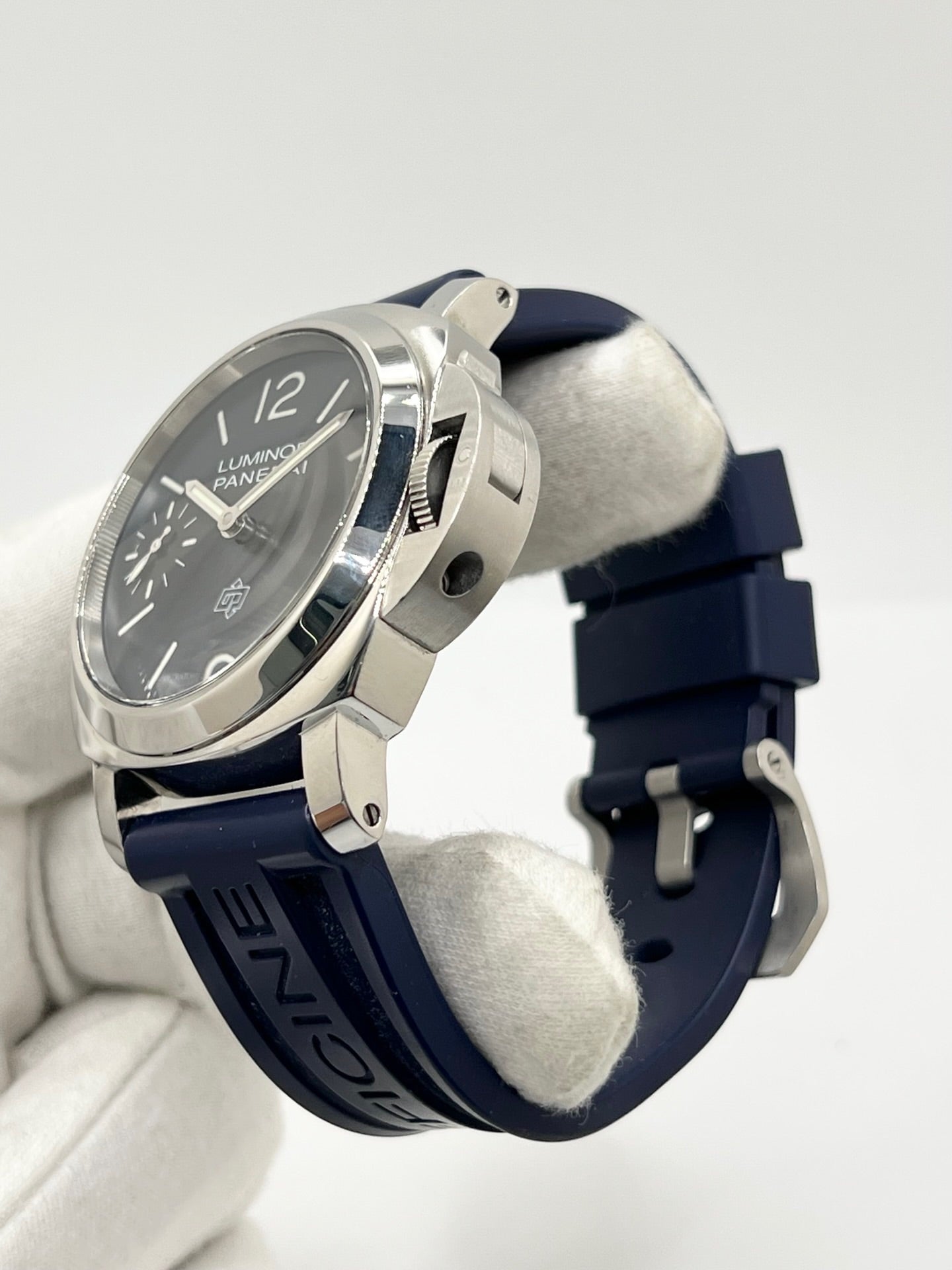 Montre Panerai Luminor Base référence PAM 01085 en acier avec boîtier de 44 mm, fabriquée en 2022 et animée par le calibre manufacture P.6000 à remontage manuel offrant 72 heures de réserve de marche. Son cadran bleu à chiffres arabes est protégé par un verre saphir et complété par un bracelet en caoutchouc bleu avec boucle ardillon en acier. Cette montre Panerai d'occasion est en très bon état, révisée en interne et livrée avec son coffret et ses papiers d'origine.