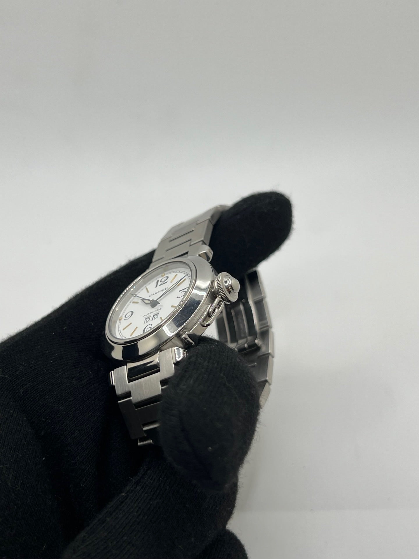 Montre de luxe Cartier Pasha C référence 2475 en acier, équipée d’un mouvement automatique calibre 052. Son boîtier de 35 mm et son cadran blanc à chiffres arabes offrent un style élégant et intemporel. Avec verre saphir, étanchéité 10 ATM et bracelet en acier, cette Pasha C combine performance, précision et raffinement.