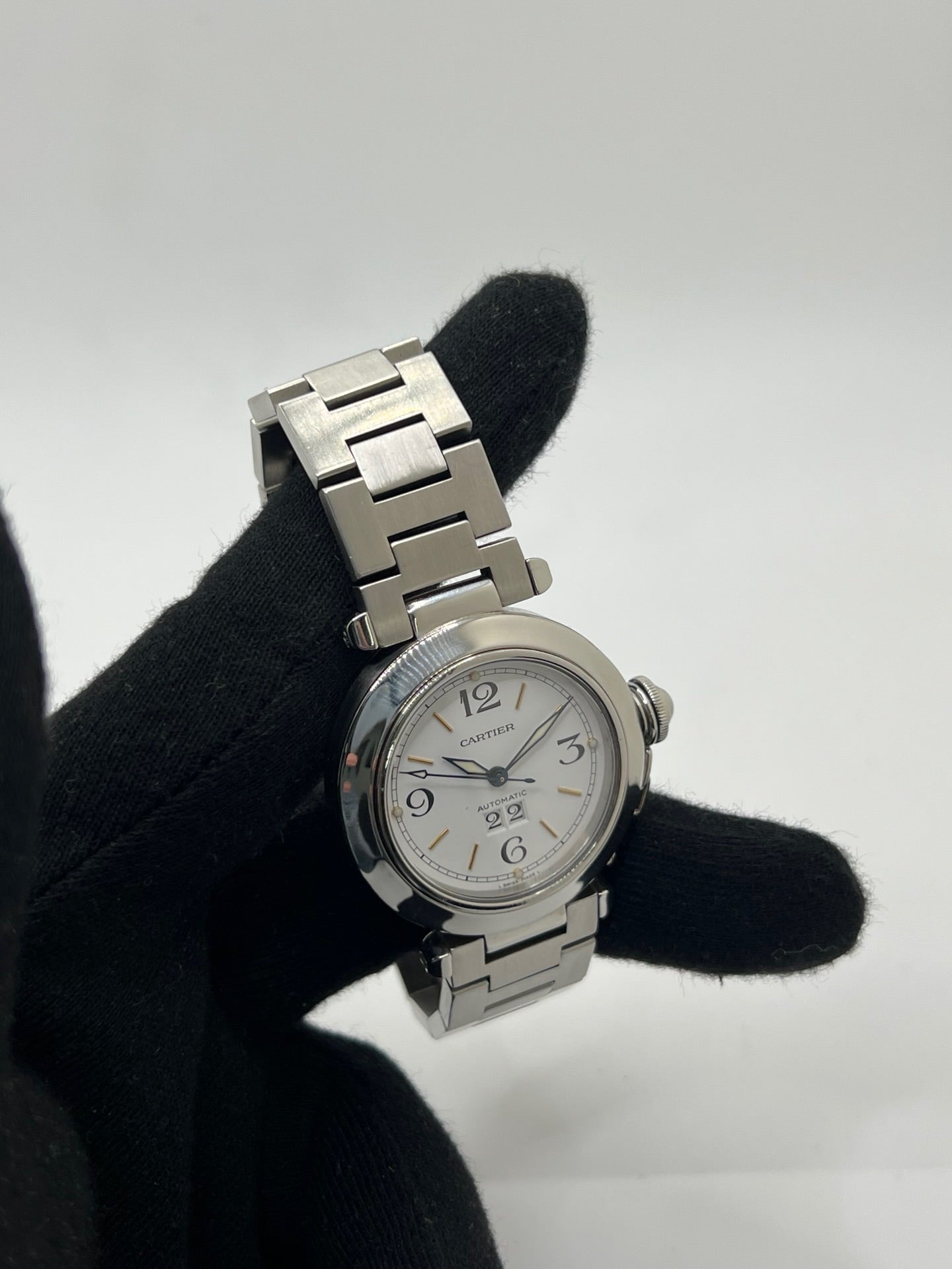 Montre de luxe Cartier Pasha C référence 2475 en acier, équipée d’un mouvement automatique calibre 052. Son boîtier de 35 mm et son cadran blanc à chiffres arabes offrent un style élégant et intemporel. Avec verre saphir, étanchéité 10 ATM et bracelet en acier, cette Pasha C combine performance, précision et raffinement.