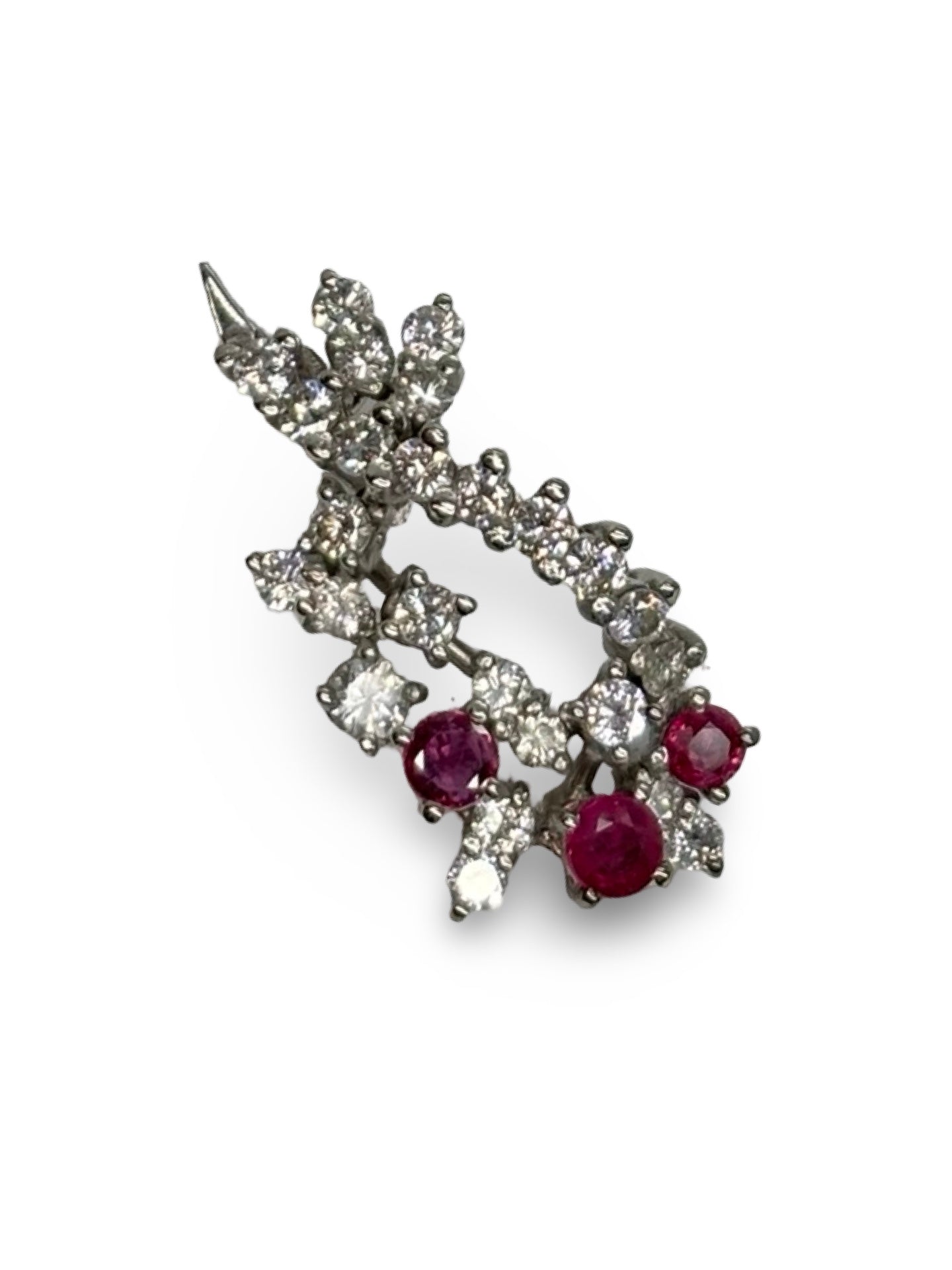 Pendentif en or blanc 18K orné de rubis totalisant 0,25 ct et de diamants de 1,2 ct. Élégant et raffiné, il associe la chaleur rouge des rubis à l’éclat lumineux des diamants. Ce bijou délicat et intemporel sublime toutes les tenues et constitue une pièce précieuse idéale pour offrir ou compléter une collection de joaillerie fine.