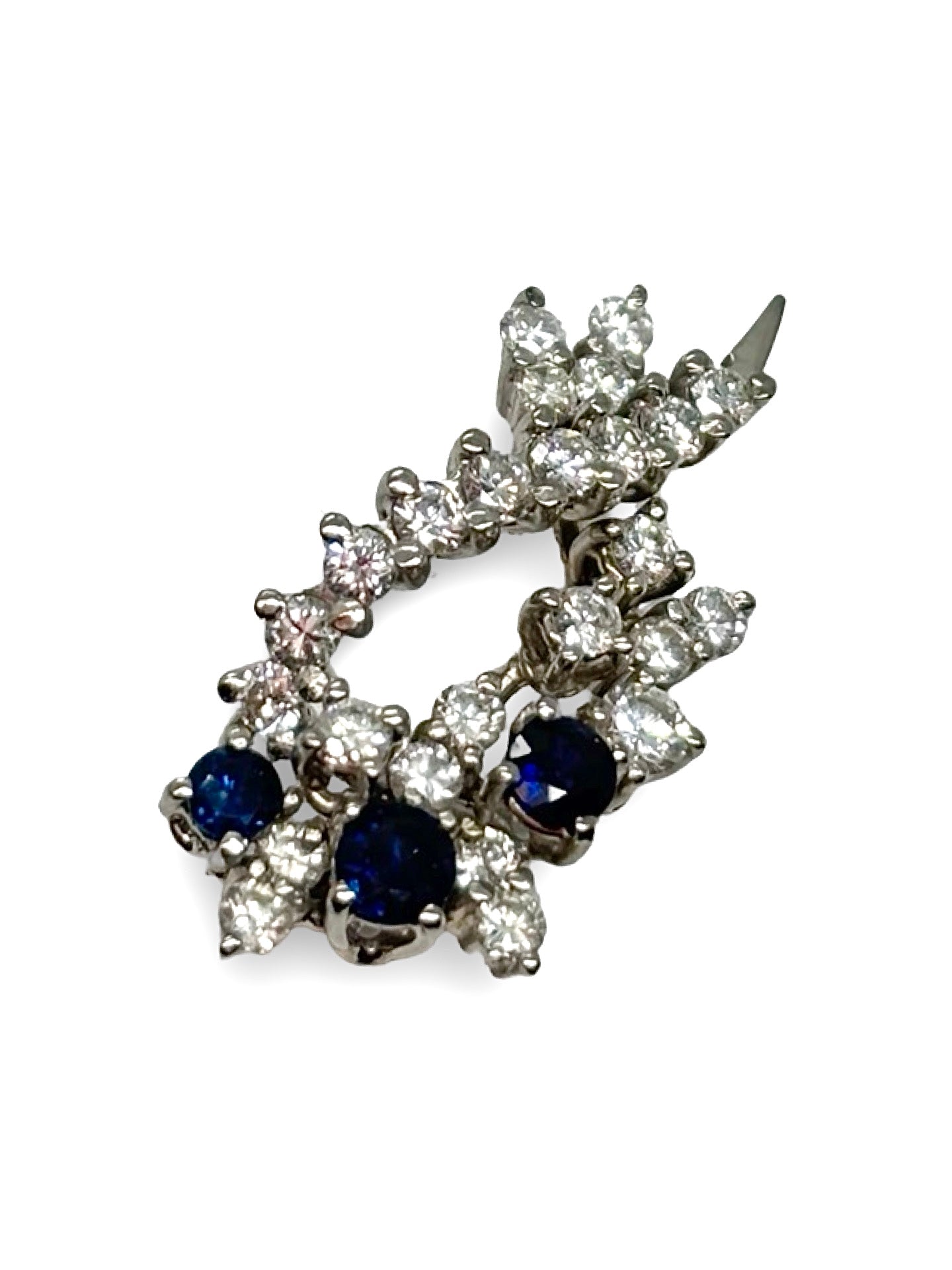 Pendentif en or blanc 18K orné de saphirs totalisant 0,25 ct et de diamants de 1,2 ct. Élégant et raffiné, il allie la profondeur bleue des saphirs à l’éclat lumineux des diamants. Ce bijou délicat et intemporel sublime toutes les tenues et constitue une pièce précieuse idéale pour un cadeau ou compléter une collection de joaillerie fine.