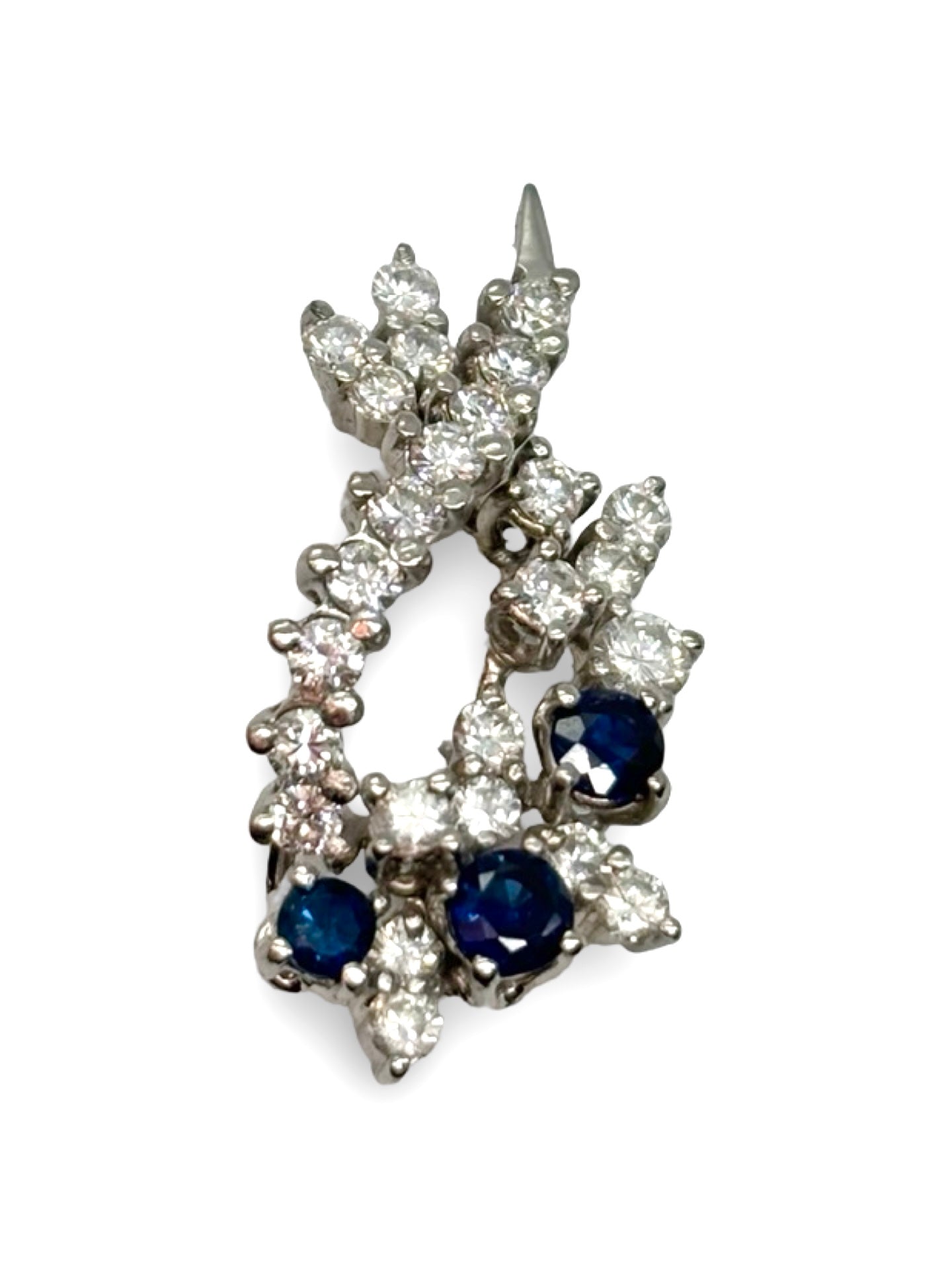 Pendentif en or blanc 18K orné de saphirs totalisant 0,25 ct et de diamants de 1,2 ct. Élégant et raffiné, il allie la profondeur bleue des saphirs à l’éclat lumineux des diamants. Ce bijou délicat et intemporel sublime toutes les tenues et constitue une pièce précieuse idéale pour un cadeau ou compléter une collection de joaillerie fine.