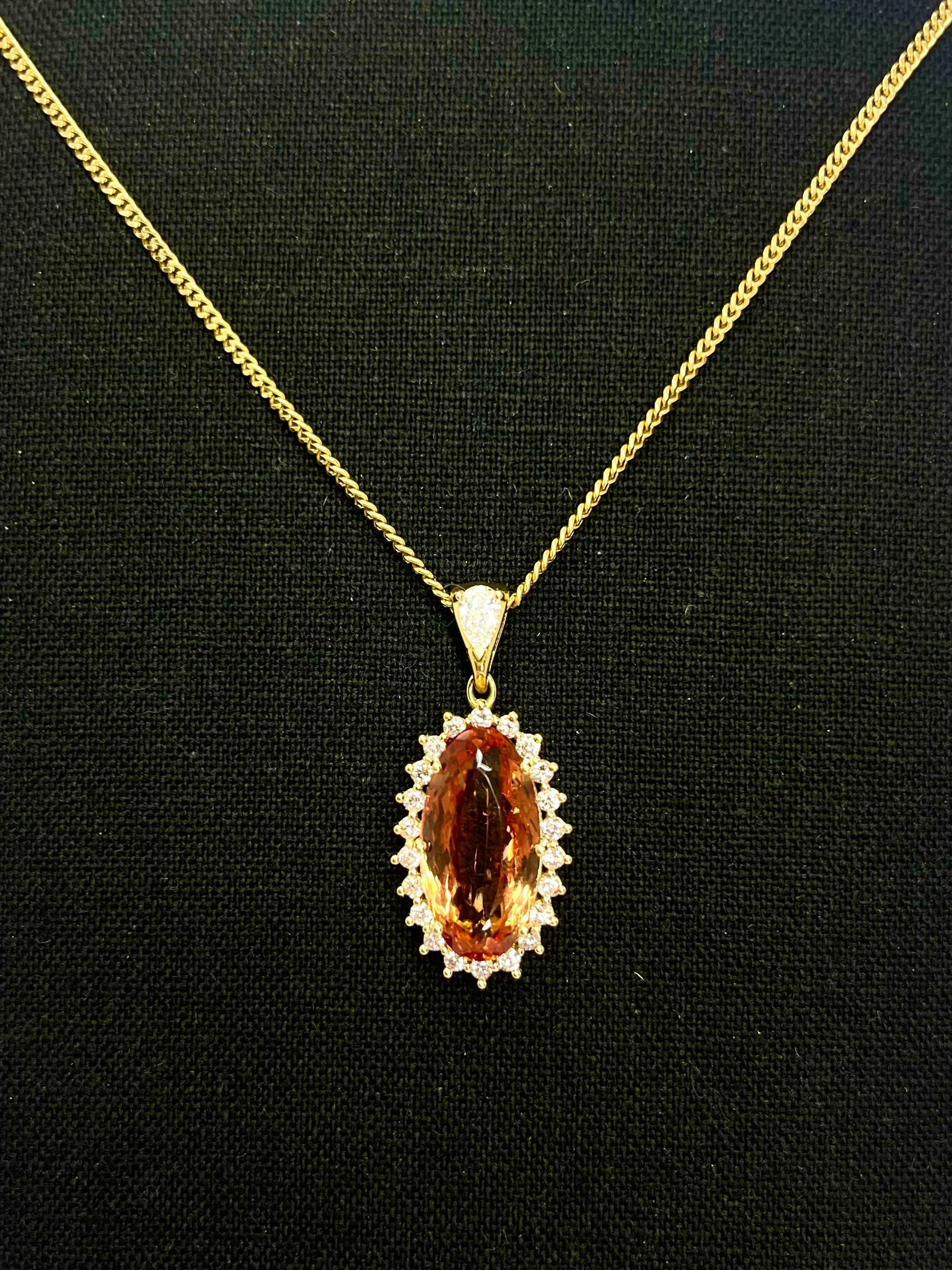 Laissez-vous charmer par ce somptueux pendentif en or, mettant en lumière une Topaze Impériale d’exception, accompagnée de diamants scintillants. Ce bijou raffiné séduit par la chaleur de sa pierre précieuse et la délicatesse de son sertissage. Une pièce unique, idéale pour sublimer une tenue élégante, livrée avec son certificat gemmologique attestant de l’authenticité et de la qualité des gemmes.