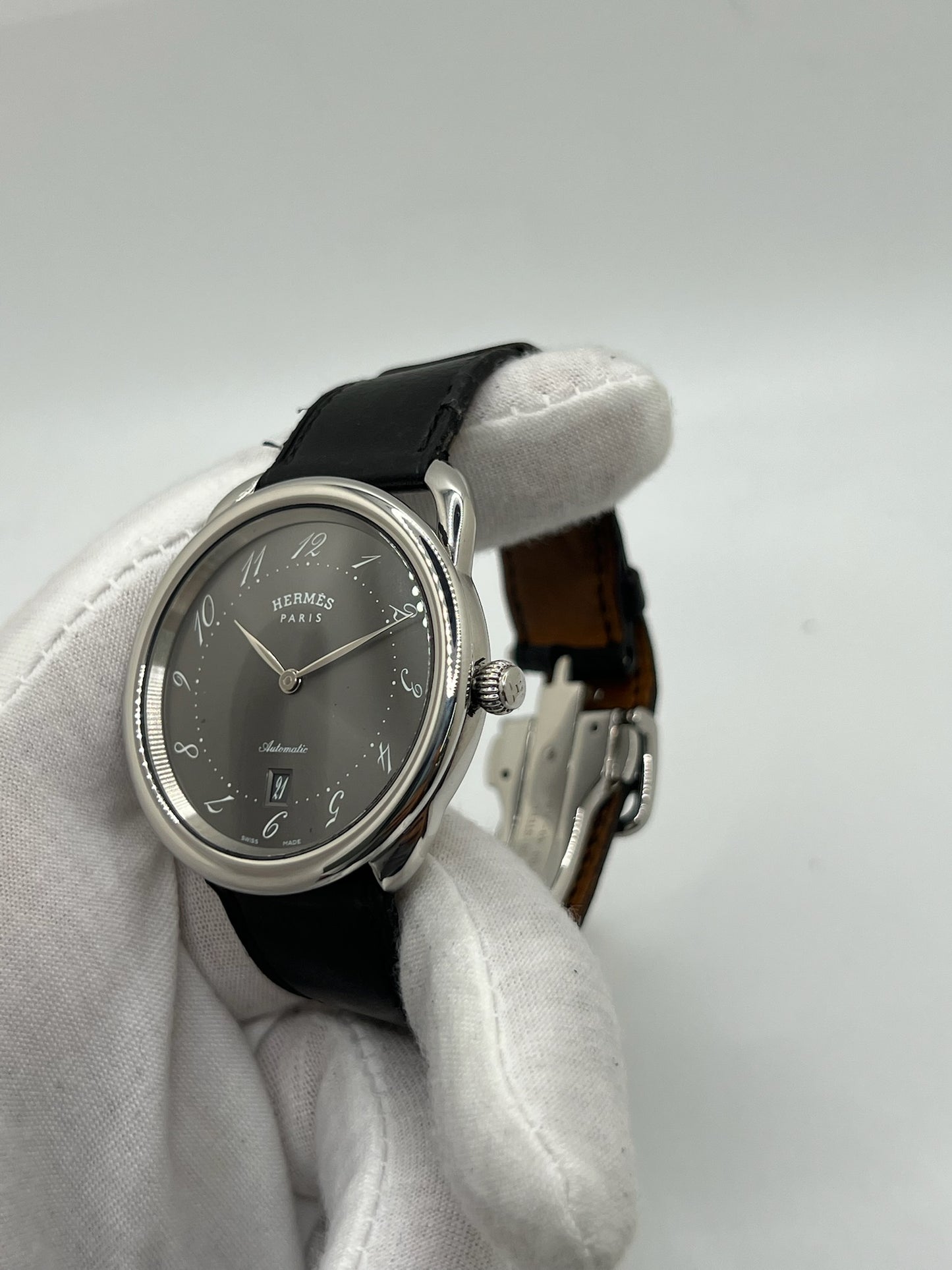 Découvrez la montre Hermès Arceau, un garde-temps d’exception alliant élégance et savoir-faire horloger. Ce modèle emblématique, doté d’un boîtier en acier de 41 mm et d’un mouvement automatique, séduit par son cadran brun raffiné et son bracelet en cuir assorti. Parfaite pour les amateurs de montres de luxe, l’Arceau incarne l’élégance à la française. 