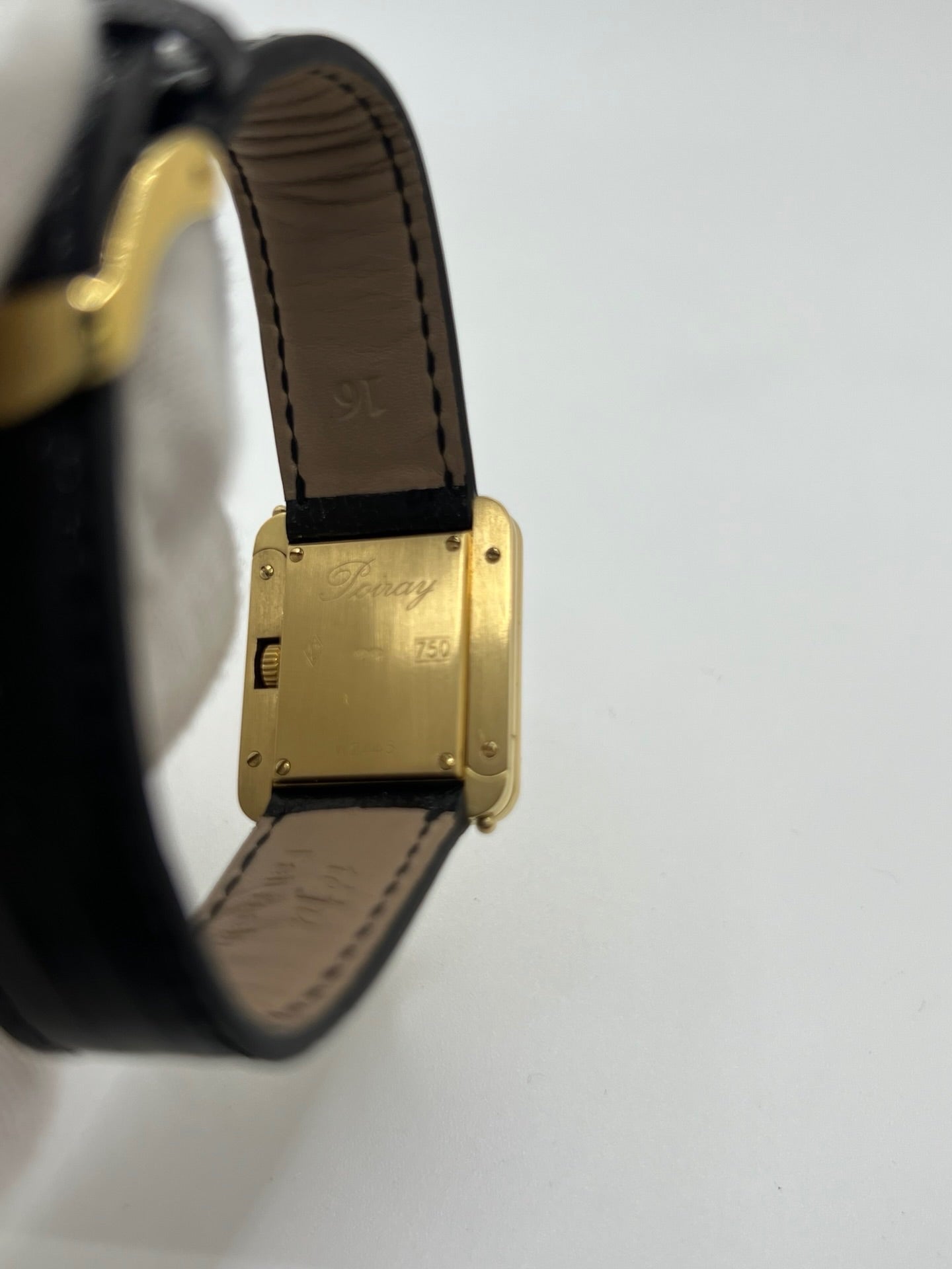 Montre femme Poiray Ma Première en or jaune 18K avec boîtier rectangulaire 22 x 26 mm, cadran doré sans chiffres et verre saphir. Modèle élégant équipé d’un mouvement quartz, bracelet en cuir noir et boucle en acier. Pièce d’occasion en très bon état présentant de légères traces d’usure non perceptibles. Montre raffinée, révisée récemment, idéale pour un style intemporel.