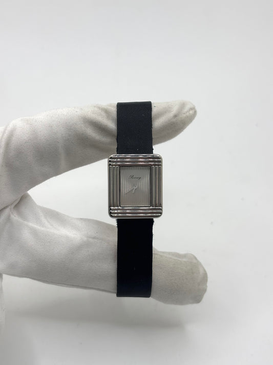 Montre Poiray Ma Première petit modèle en acier avec boîtier de 21,30 × 18,20 mm, cadran blanc épuré sans chiffres et verre minéral. Animée par un mouvement quartz, cette montre femme est équipée de son bracelet textile noir et de sa boucle ardillon d'origine en acier. Révisée, en excellent état et garantie 1 an, cette montre de luxe au style intemporel incarne l'élégance parisienne et le savoir-faire horloger de la maison Poiray.