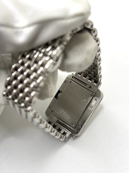 Montre Poiray Ma Première pour femme en acier inoxydable avec boîtier rectangulaire de 22,5 x 26 mm. Cette montre quartz arbore un cadran argenté protégé par un verre saphir et un bracelet en acier à boucle double pliant. Élégante et intemporelle, cette montre de luxe féminine d'occasion séduit par son design emblématique et sa finition raffinée. Modèle iconique de la maison Poiray, idéal pour les amateurs d'horlogerie et de joaillerie française.
