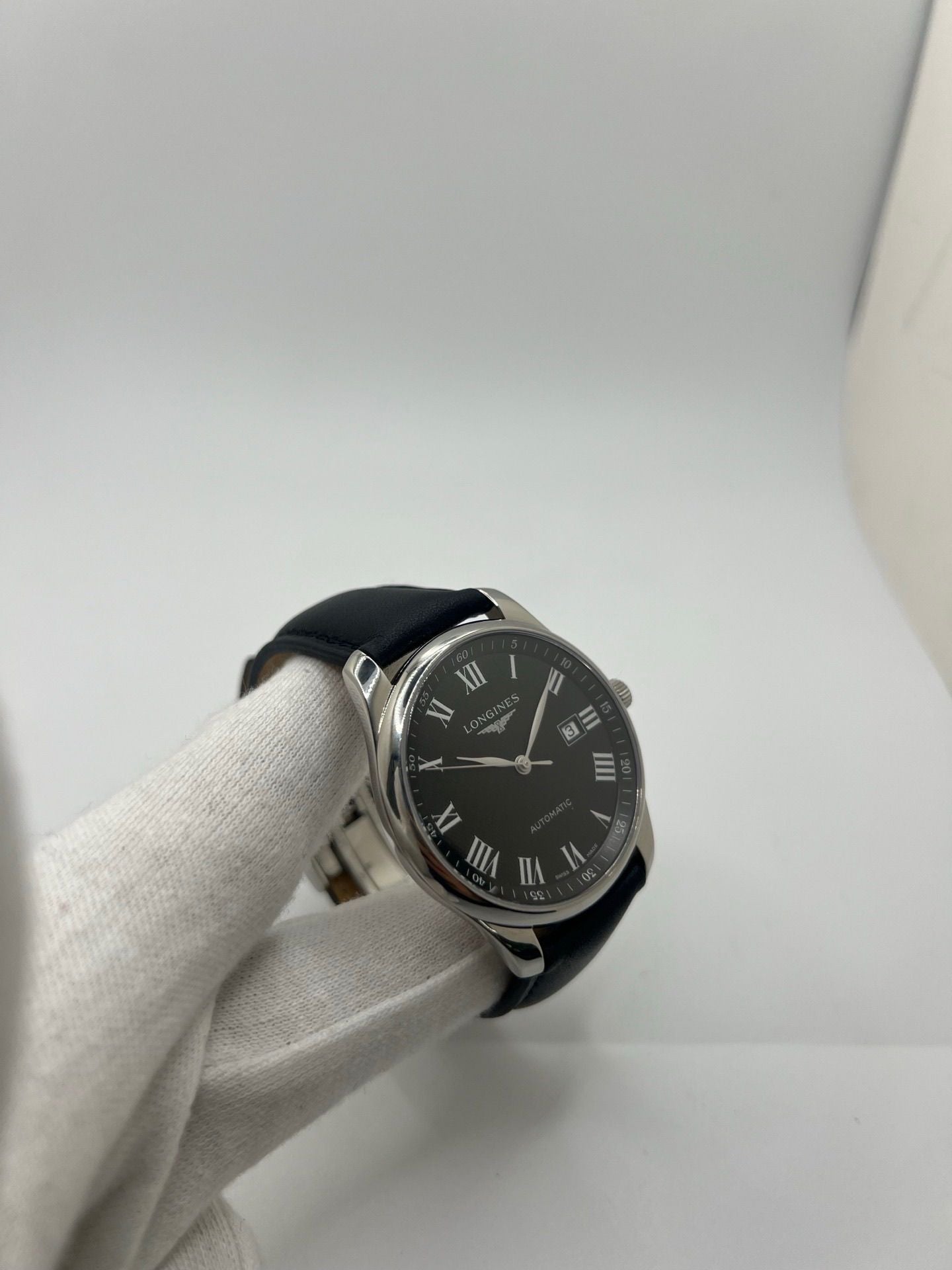 Montre automatique Longines Master Collection L2.893.4.51.6 en acier 42 mm, équipée d’un cadran noir épuré, d’un verre saphir et d’un bracelet en cuir noir. Modèle élégant avec fonction date, en très bon état d’occasion, présentant de légères micro-rayures, livré avec coffret d’origine.