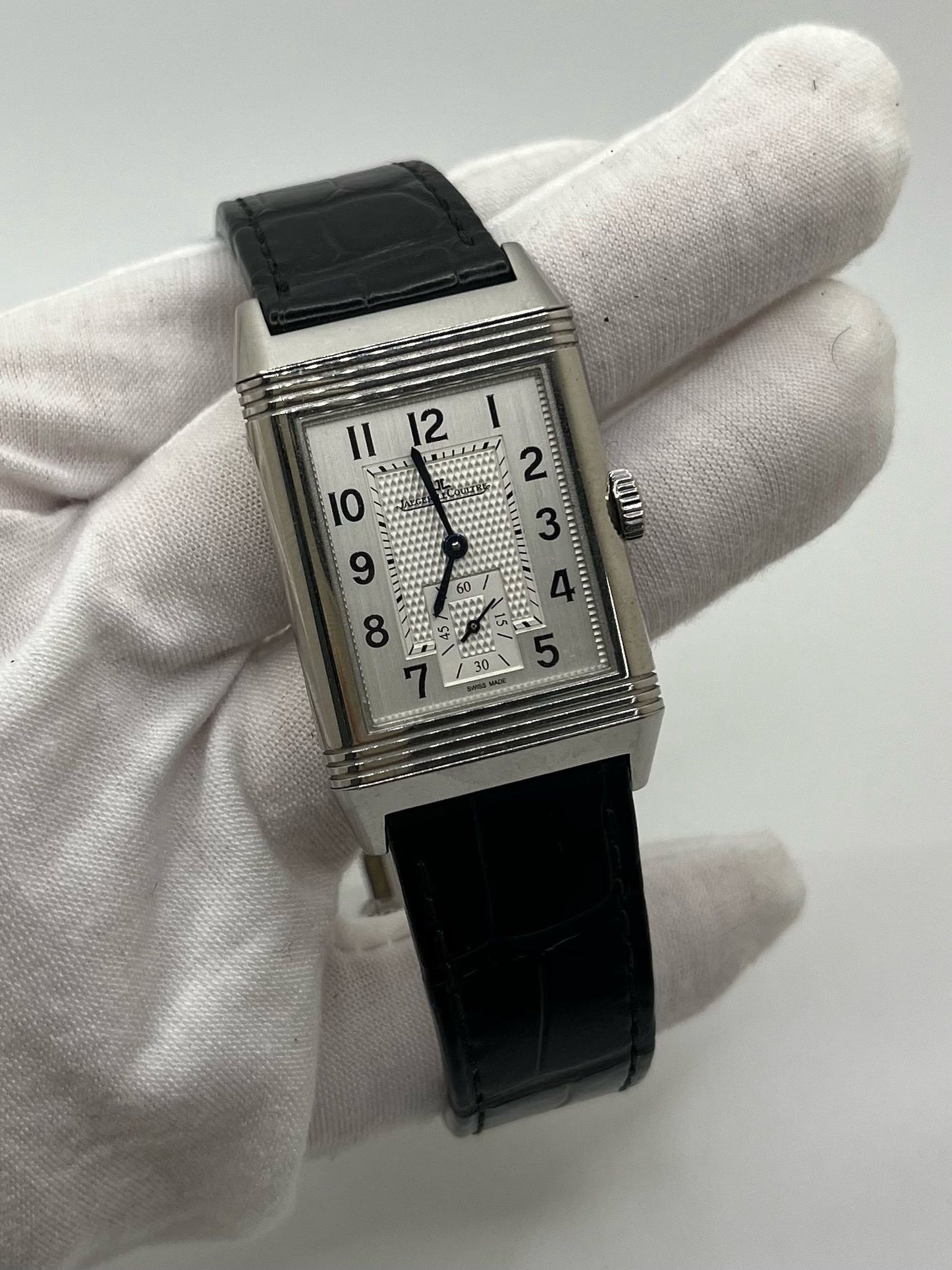 Montre Jaeger-LeCoultre Reverso Classic Small/Large réf. 214.8.62, modèle emblématique de 2017, livrée en full set avec boîte et papiers d’origine. Équipée d’une élégante boucle déployante, cette montre mécanique incarne le savoir-faire horloger suisse. Boîtier rectangulaire en acier, mouvement à remontage manuel. Une pièce raffinée pour collectionneur ou amateur de montres de prestige.