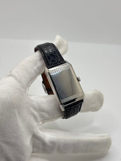 Montre Jaeger-LeCoultre Reverso Grande Taille 270.8.62 en acier, mouvement mécanique à remontage manuel calibre 822. Boîtier rectangulaire 26 x 42 mm, cadran argent à chiffres arabes, petite seconde, verre saphir. Bracelet cuir noir boucle ardillon acier. Modèle 1997 en très bon état, révisé le 4 juin 2026, livré avec coffret et papiers d’origine. Montre de luxe suisse emblématique, design Art déco, style vintage élégant. pièce horlogère iconique.
