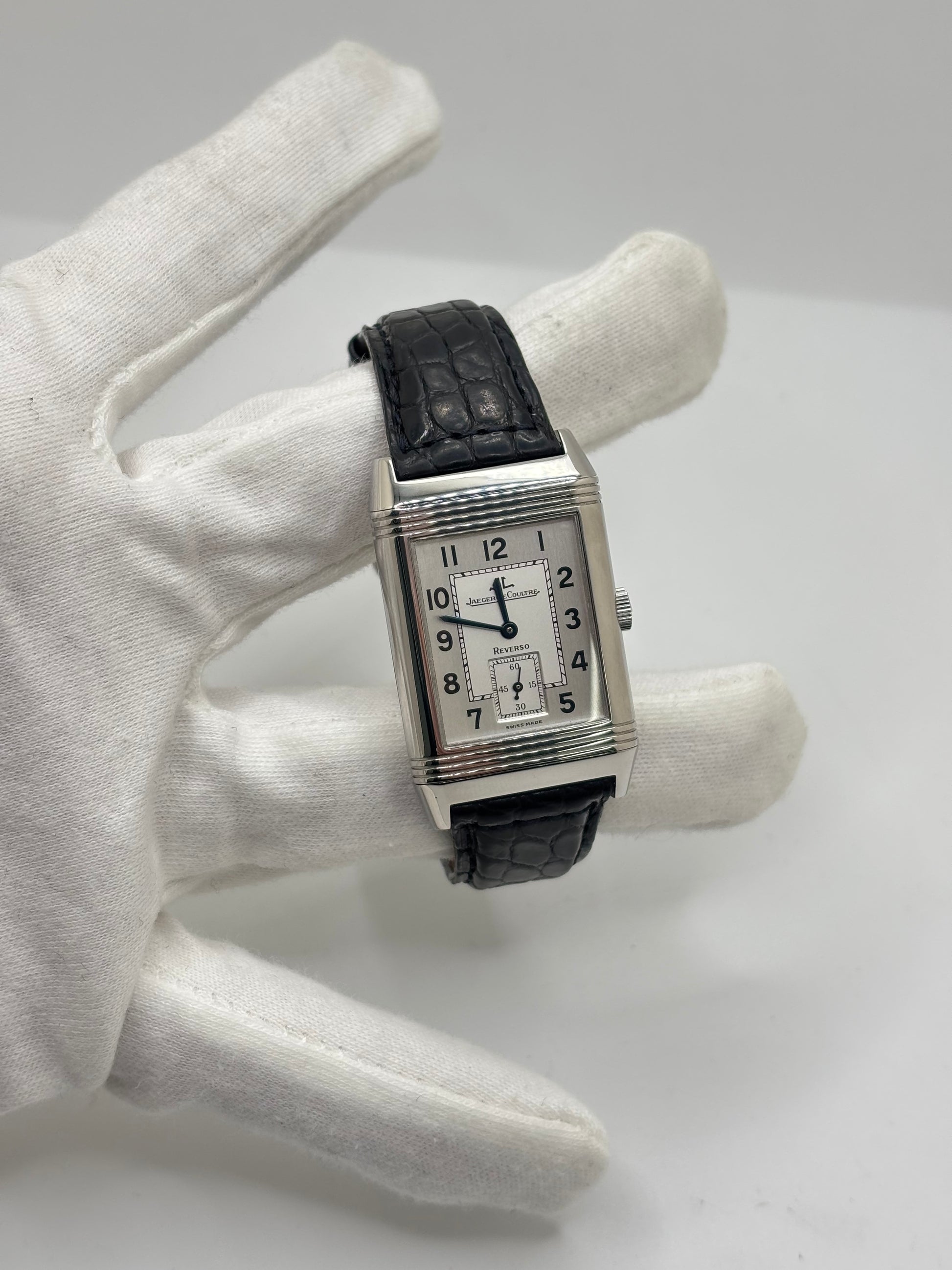 Montre Jaeger-LeCoultre Reverso Grande Taille 270.8.62 en acier, mouvement mécanique à remontage manuel calibre 822. Boîtier rectangulaire 26 x 42 mm, cadran argent à chiffres arabes, petite seconde, verre saphir. Bracelet cuir noir boucle ardillon acier. Modèle 1997 en très bon état, révisé le 4 juin 2026, livré avec coffret et papiers d’origine. Montre de luxe suisse emblématique, design Art déco, style vintage élégant. pièce horlogère iconique.
