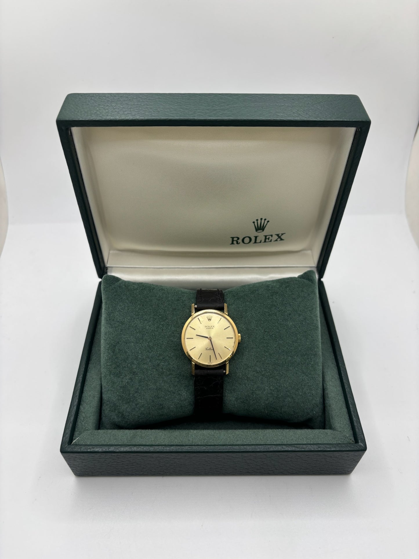 Montre Rolex Cellini référence 4109 vintage en or jaune de 1976, équipée d’un mouvement à remontage manuel calibre 1601. Boîtier de 26 mm en or jaune avec lunette assortie, cadran doré à index bâtons et verre saphir. Bracelet en cuir noir avec boucle ardillon en acier. Montre femme élégante d’occasion en bon état présentant des traces d’usure visibles (rayures et petites marques). Révisée en interne le 30 juin 2026, livrée avec coffret d’origine sans papiers.