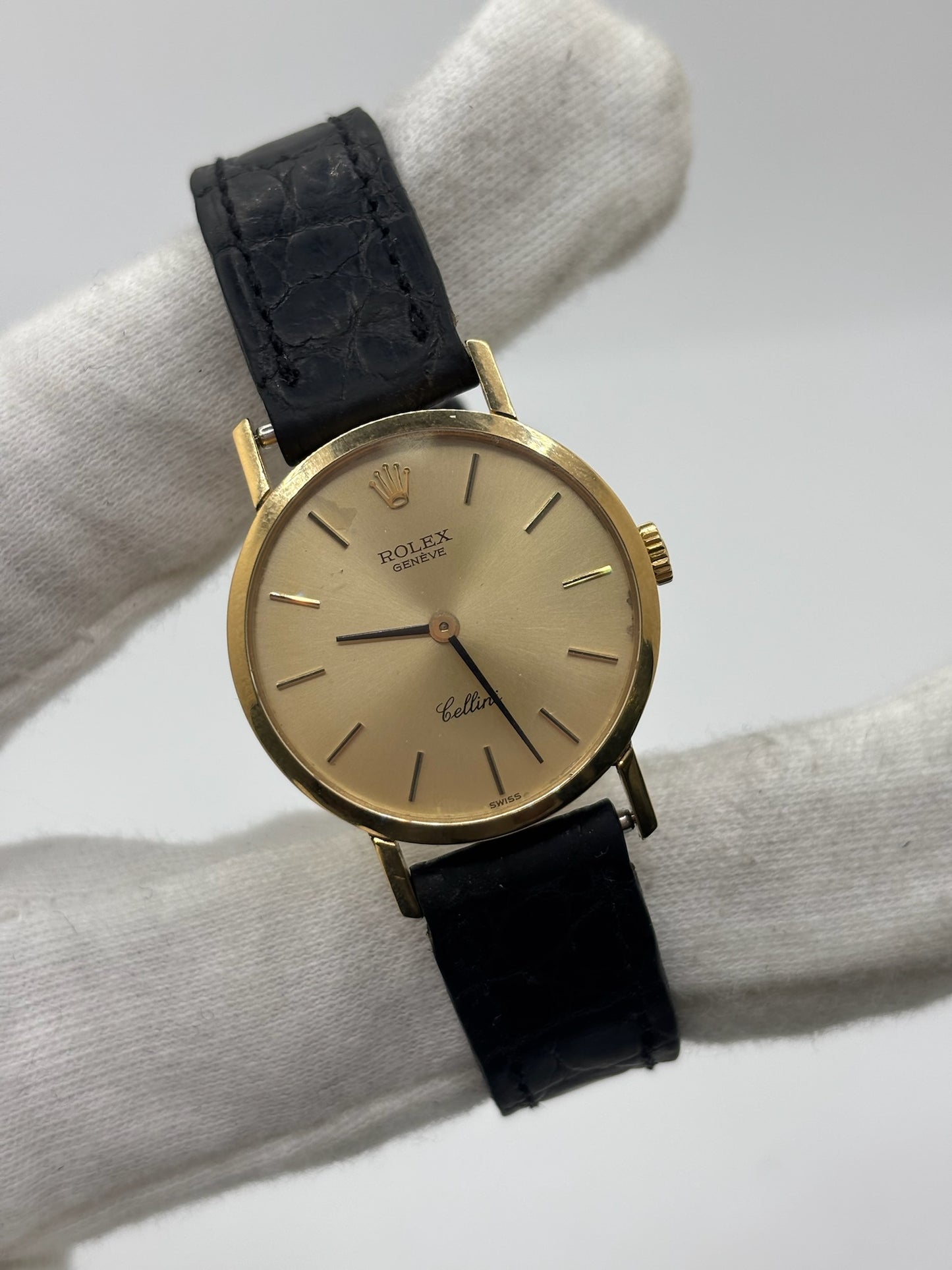 Montre Rolex Cellini référence 4109 vintage en or jaune de 1976, équipée d’un mouvement à remontage manuel calibre 1601. Boîtier de 26 mm en or jaune avec lunette assortie, cadran doré à index bâtons et verre saphir. Bracelet en cuir noir avec boucle ardillon en acier. Montre femme élégante d’occasion en bon état présentant des traces d’usure visibles (rayures et petites marques). Révisée en interne le 30 juin 2026, livrée avec coffret d’origine sans papiers.